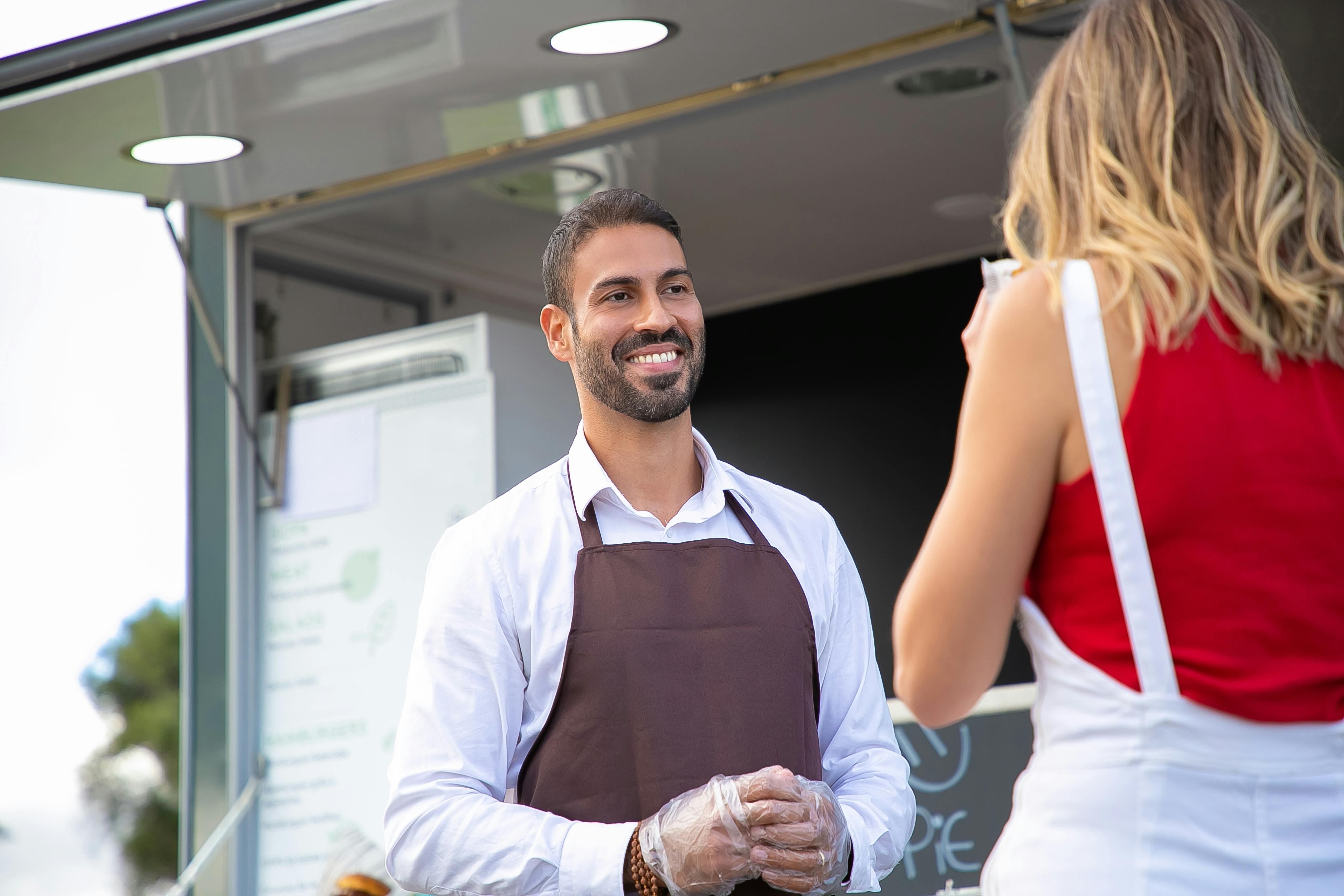 Le propriétaire d'un café discute avec un client | Source : Pexels