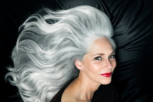 Une femme avec ses longs cheveux gris argentés, brillants, ondulés. | Photo : Getty Images