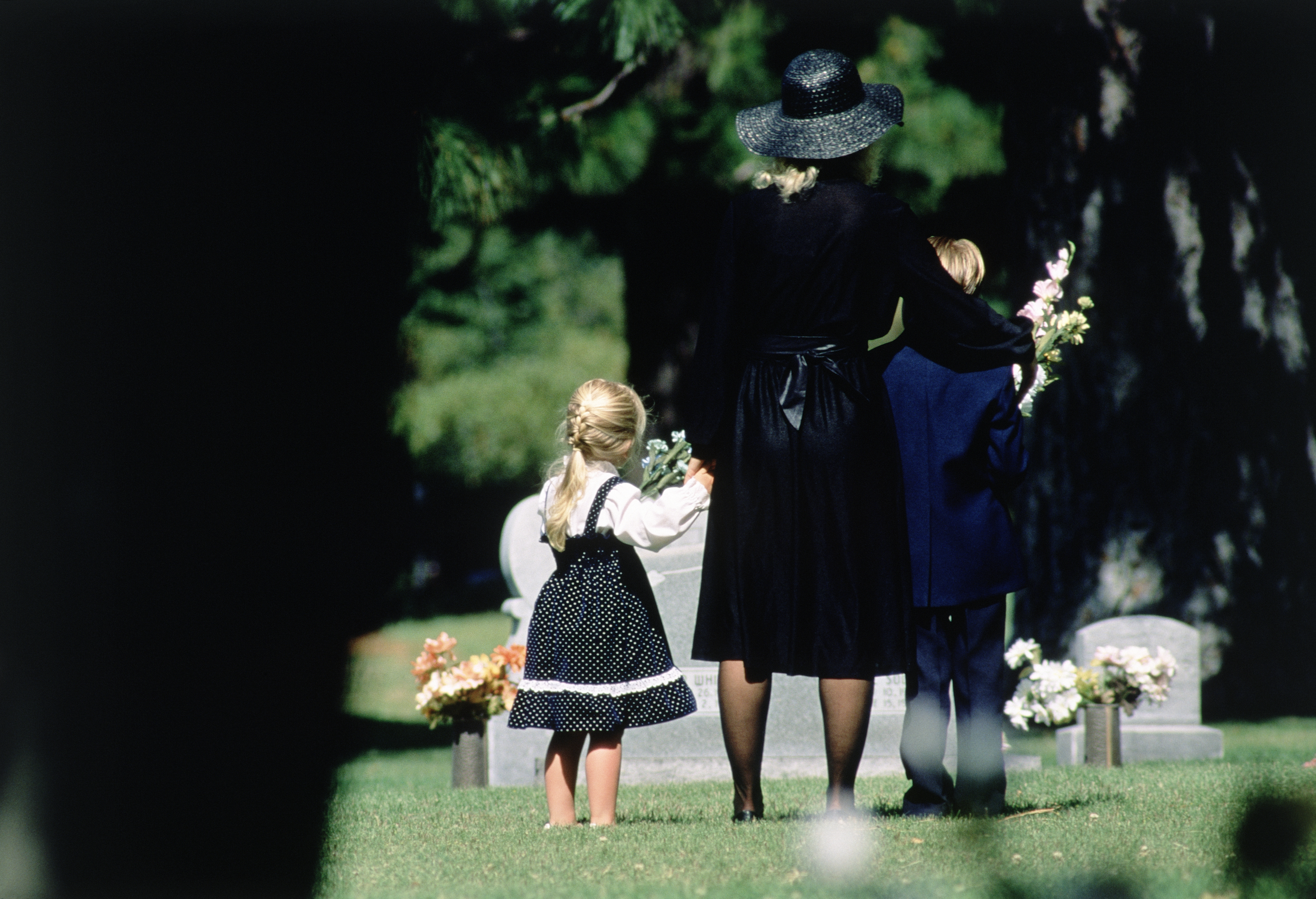 Une mère et ses enfants assistant à un enterrement | Source : Getty Images