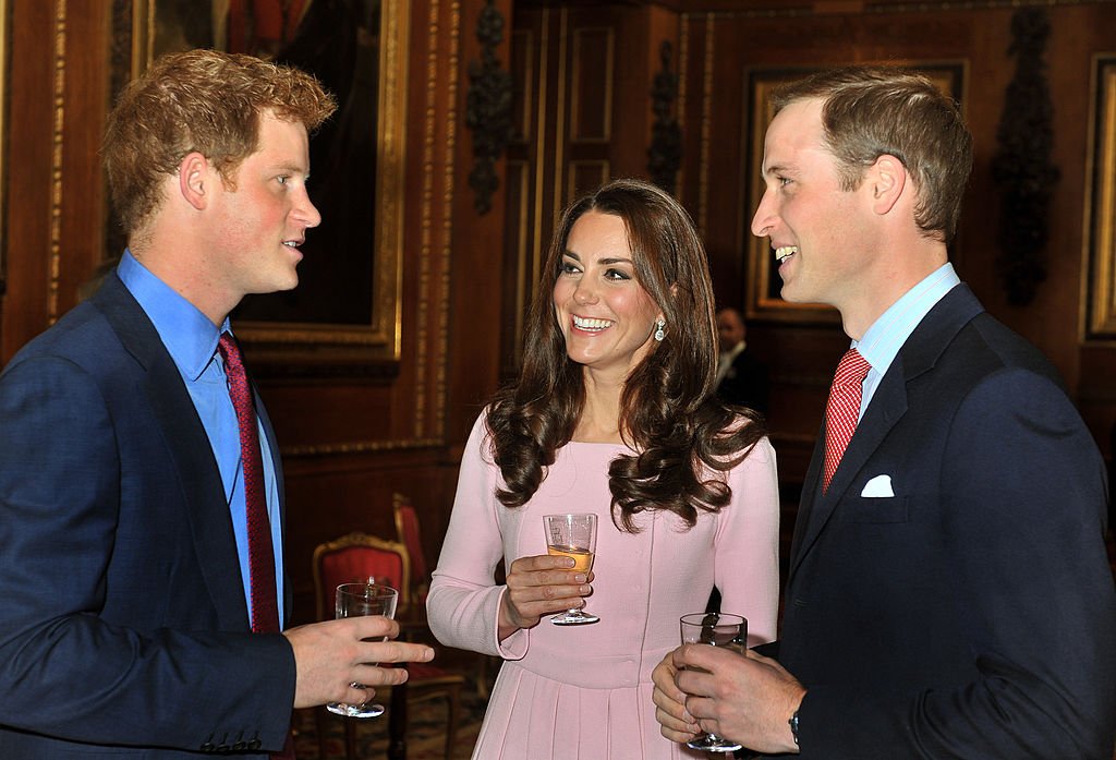 Kate et le prince William s'adressent au prince Harry lors d'une réception dans la salle de Waterloo, avant le déjeuner des monarques souverains au château de Windsor, le 18 mai 2012 à Windsor, en Angleterre. І Source : Getty Images