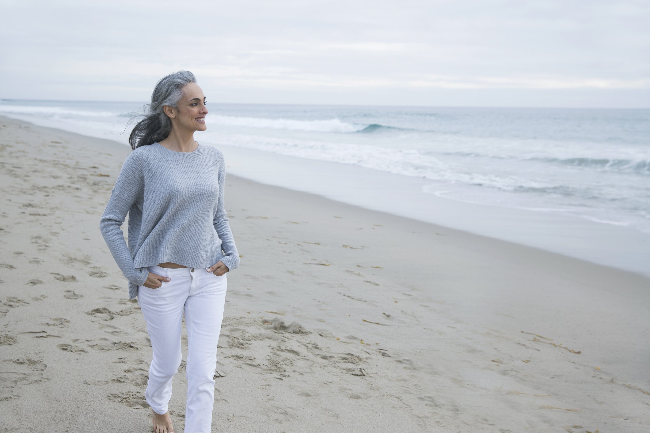 Une femme marchant sur la plage | source : Getty images