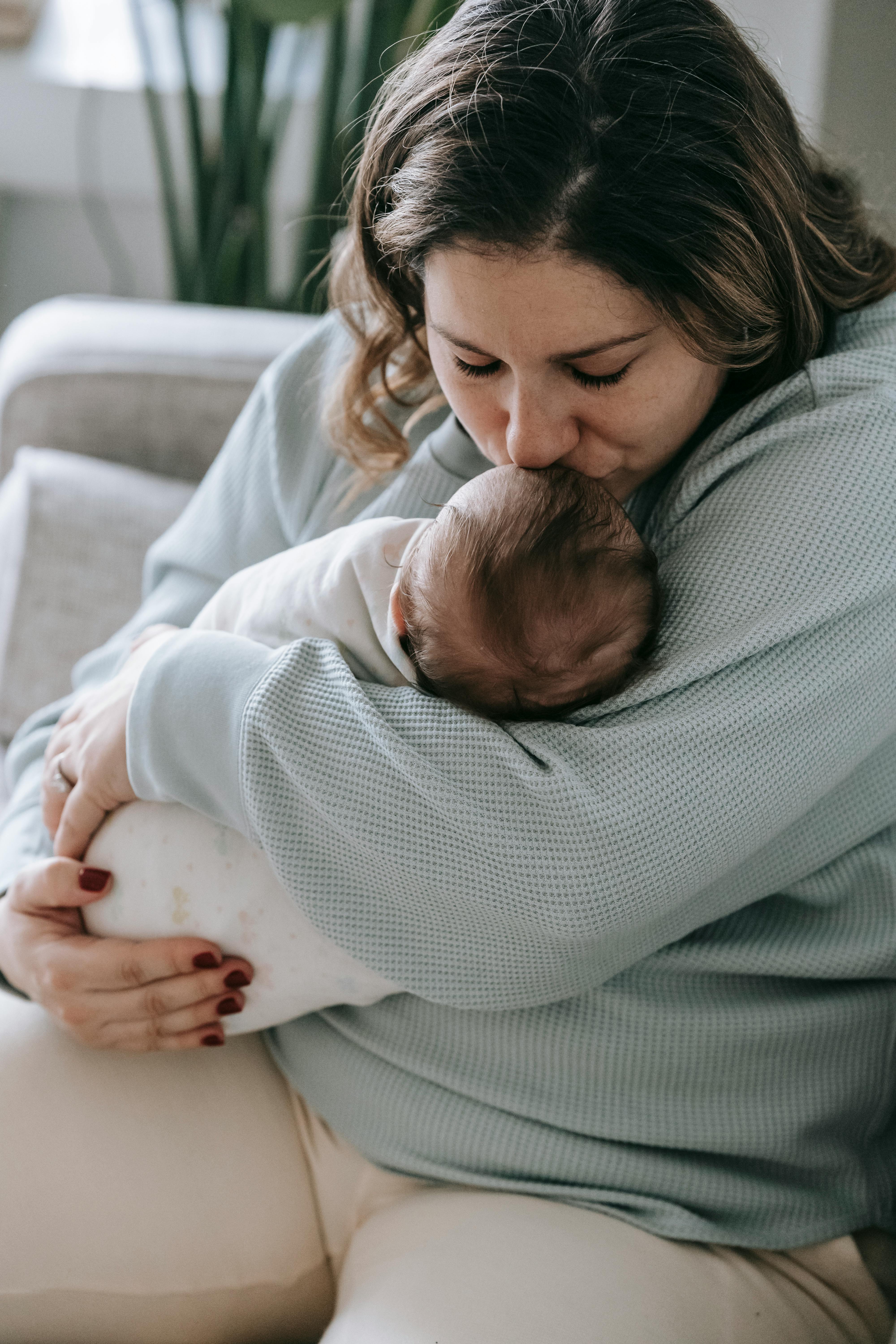 Une femme embrassant le front de son bébé | Source : Pexels