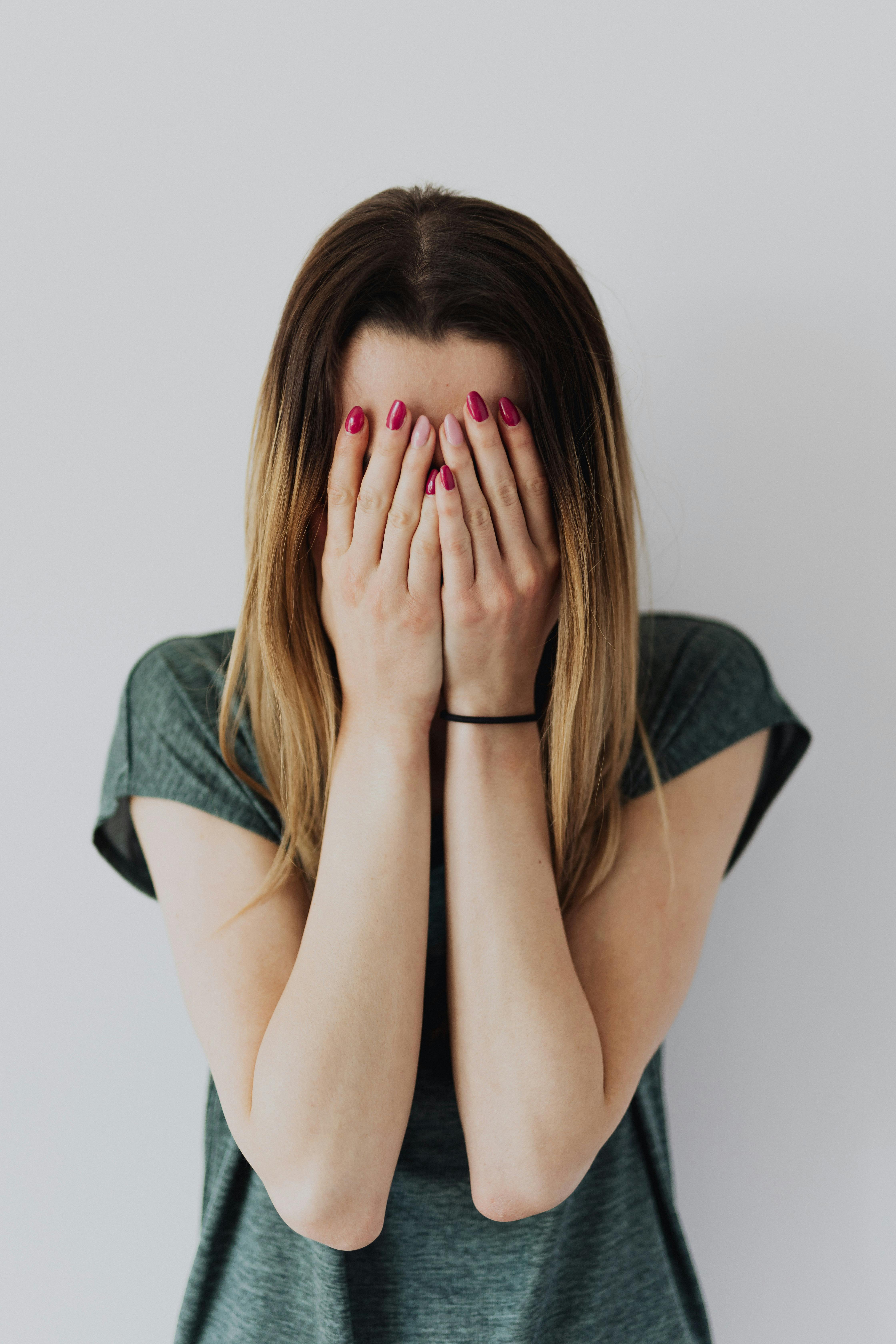 Une jeune femme se couvrant le visage avec ses mains | Source : Pexels