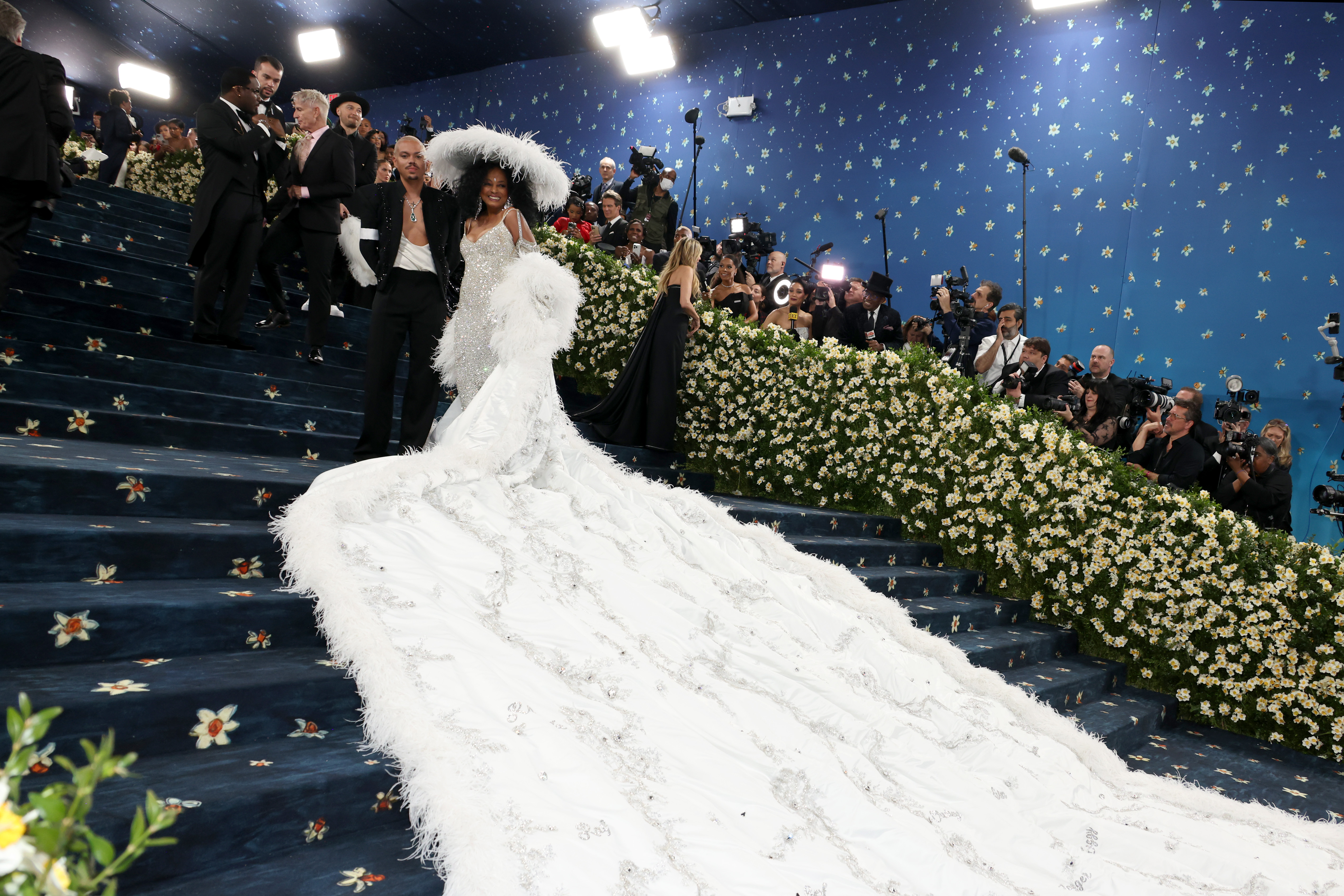 Ross est rejointe par son fils Evan Ross pour une photo saisissante dans l'escalier. Il porte un costume noir distinctif orné de broderies noires scintillantes, associé à un haut blanc impeccable en dessous. Debout côte à côte, le duo mère-fils se complète sans effort