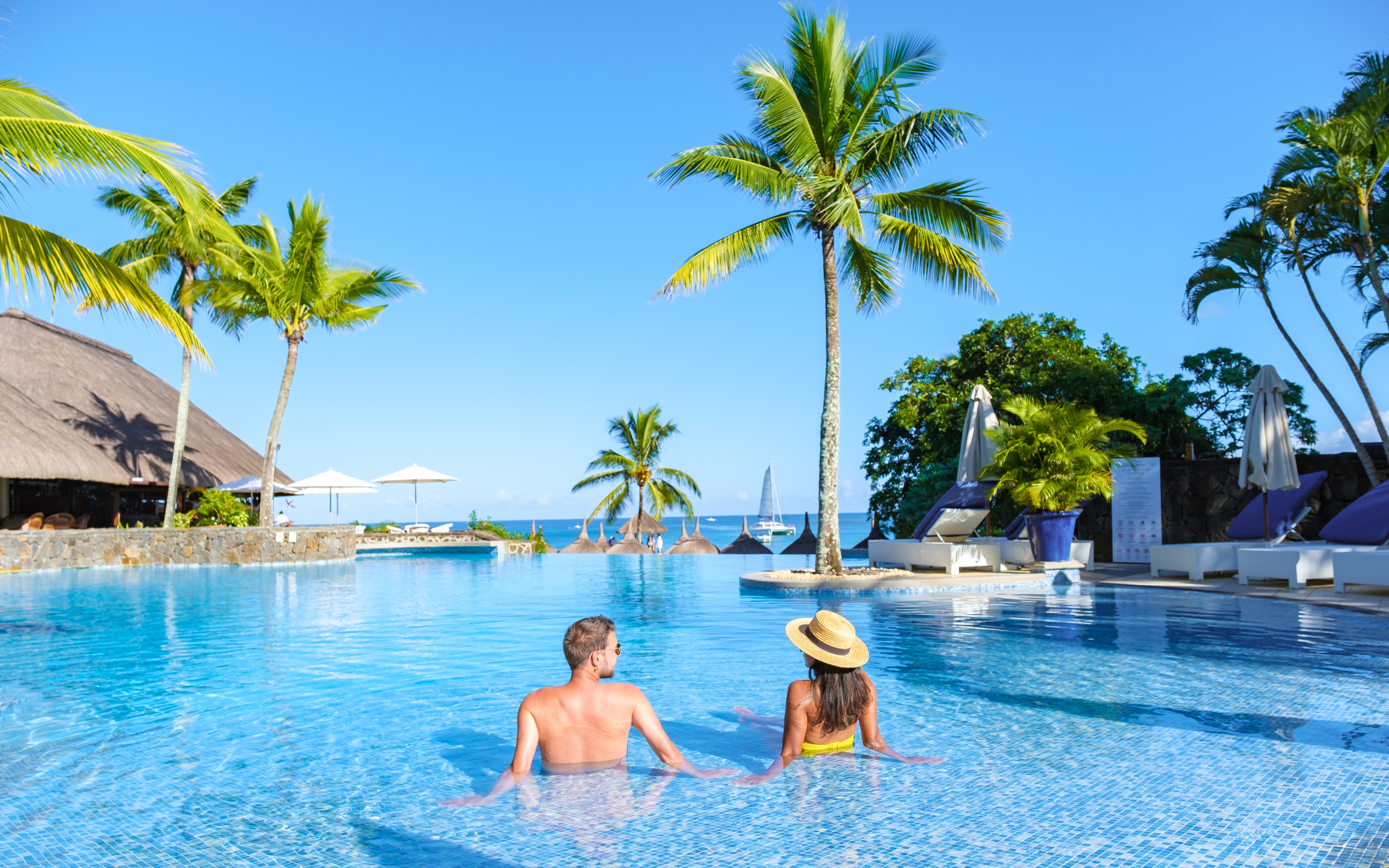 Un couple se détend dans une piscine pendant les vacances | Source : Shutterstock