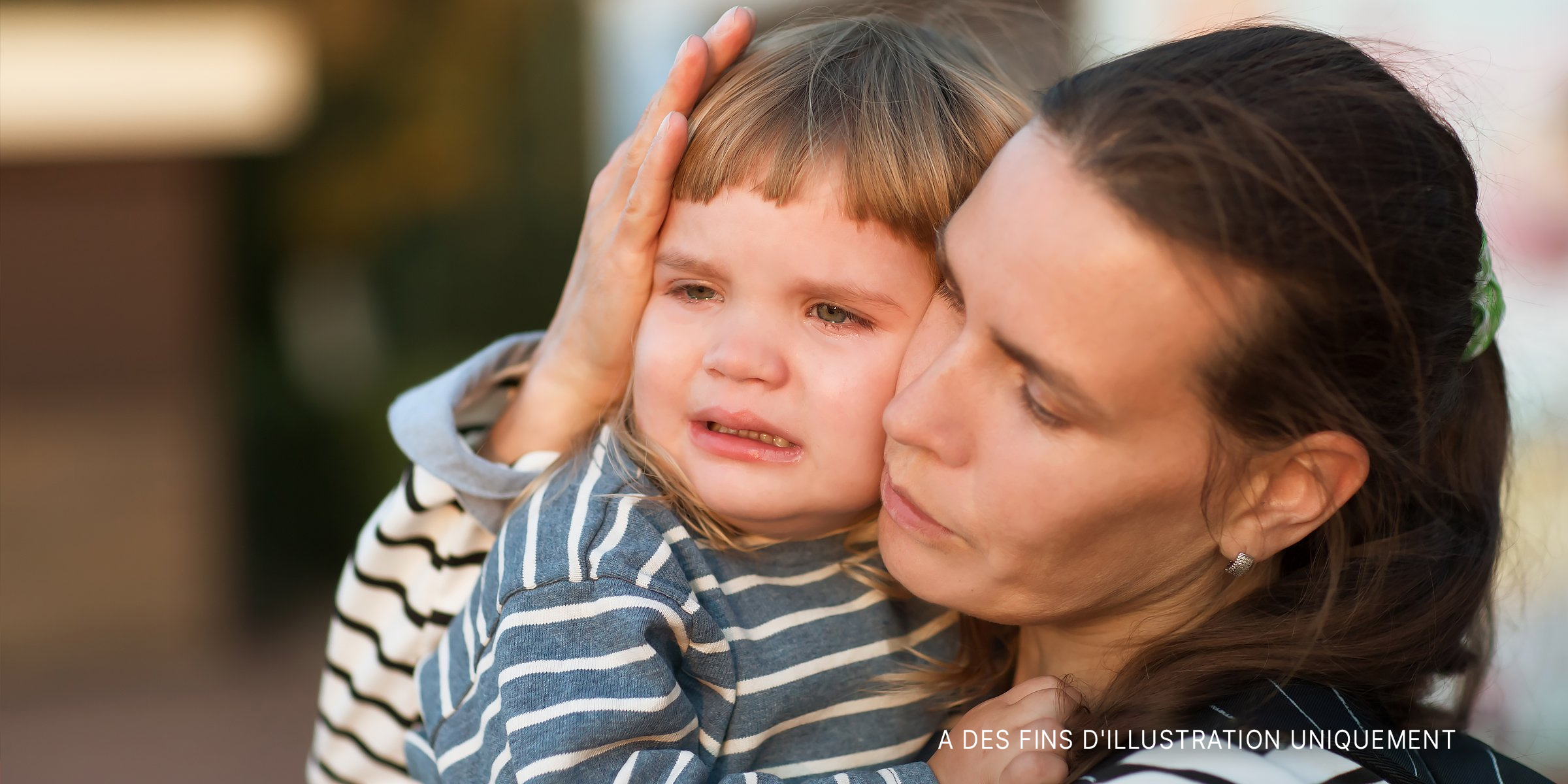 Une femme console un enfant qui pleure. | Source : Shutterstock