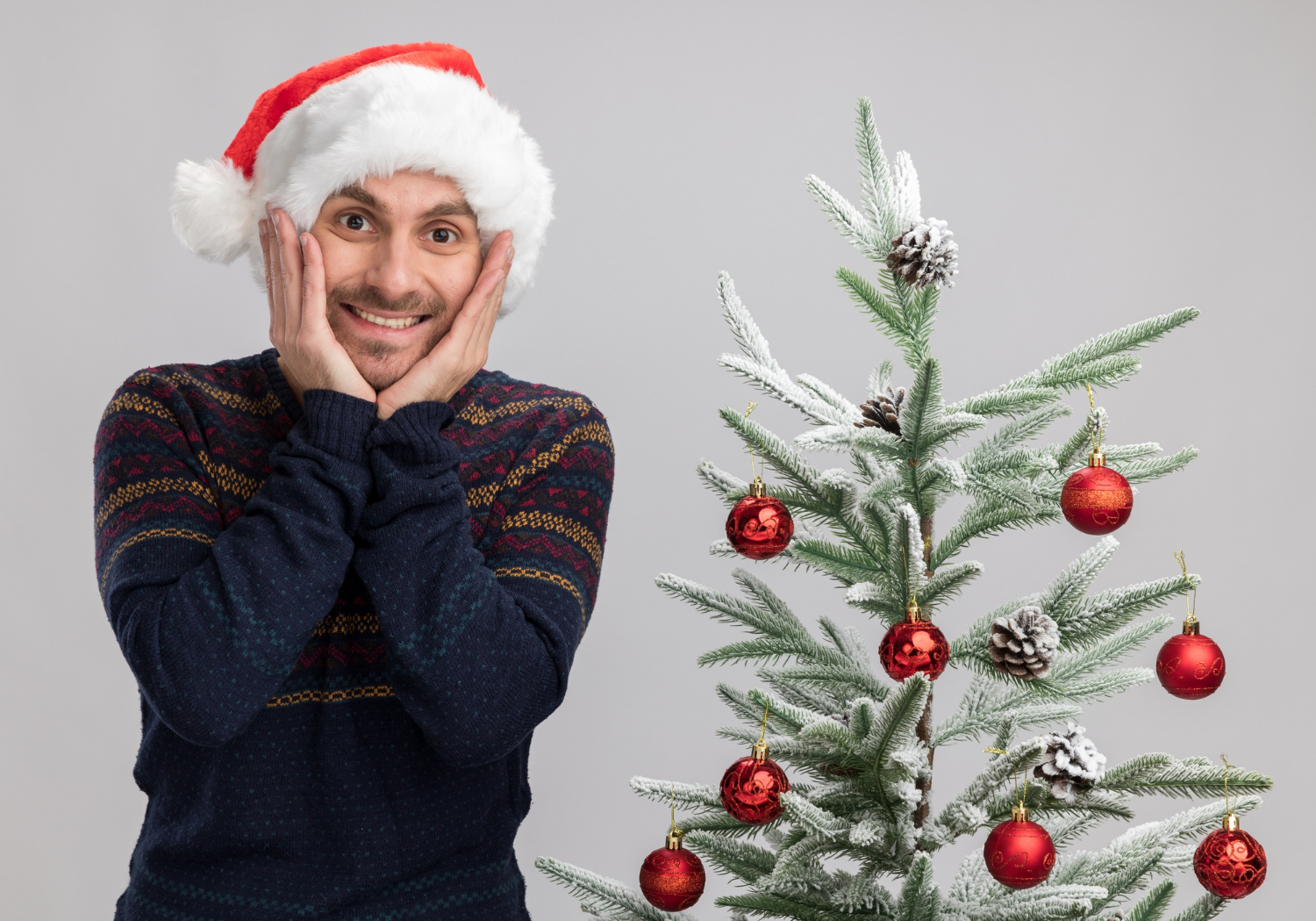 Un homme excité se tenant près d'un arbre de Noël | Source : Freepik