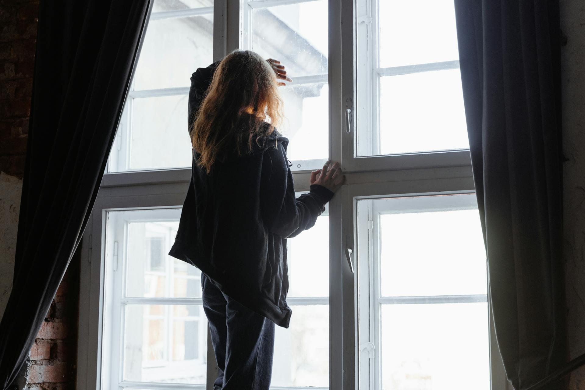 Une femme debout près d'une fenêtre | Source : Pexels