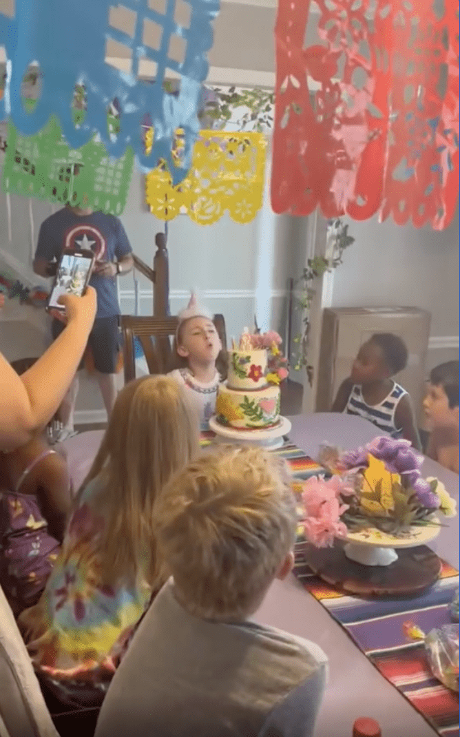 Charlotte soufflant les bougies de son gâteau lors de la célébration de son anniversaire | Source : Instagram/bluffcakes