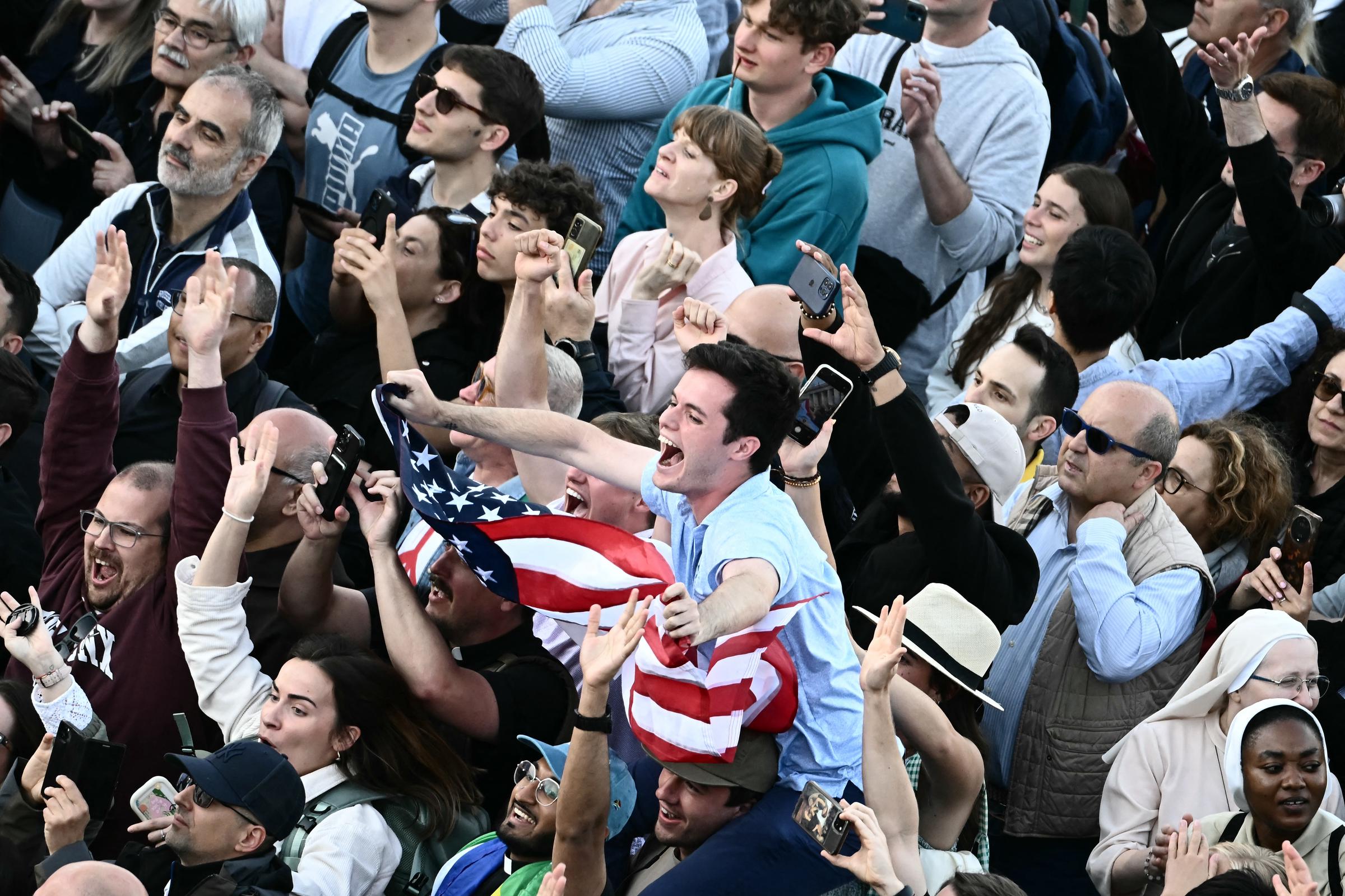 Un homme agite un drapeau américain sur la place Saint-Pierre alors que le nouveau pape est annoncé au Vatican le 8 mai 2025 | Source : Getty Images