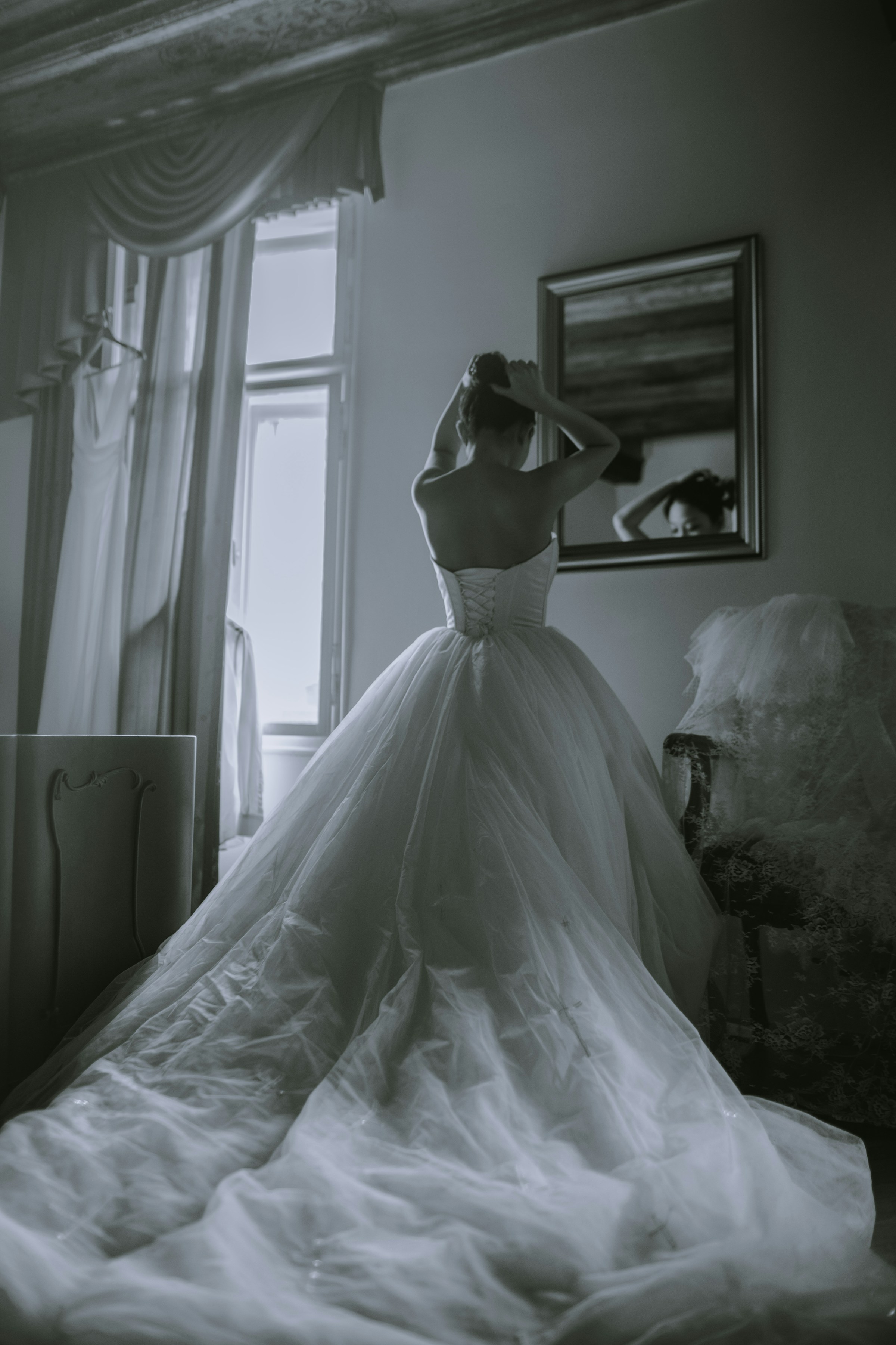 Une femme vêtue d'une robe de mariée immaculée se regarde dans le miroir | Source : Unsplash