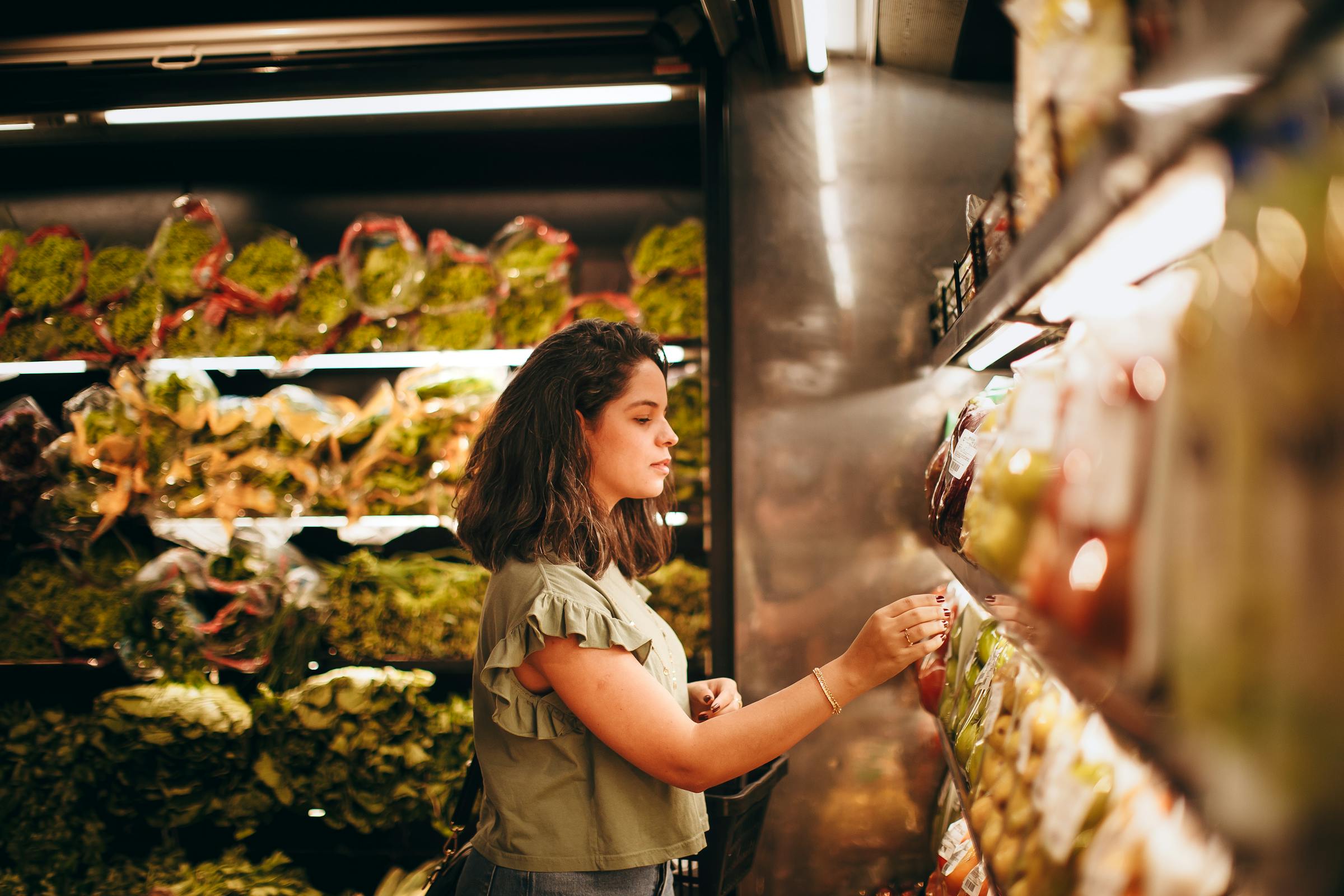 Une femme au rayon fruits et légumes d'une épicerie | Source : Pexels