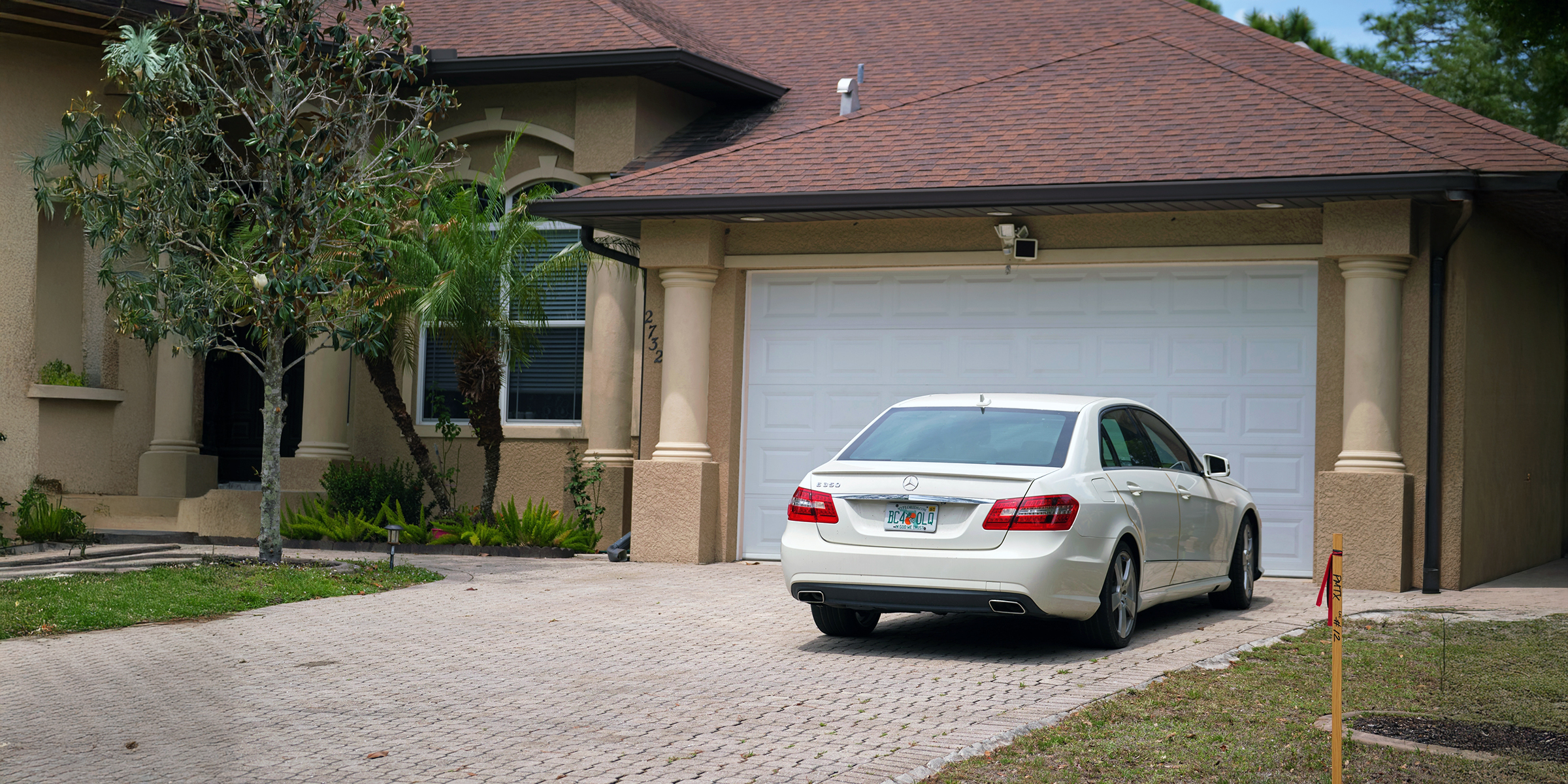 Une voiture garée devant une belle maison | Source : Shutterstock