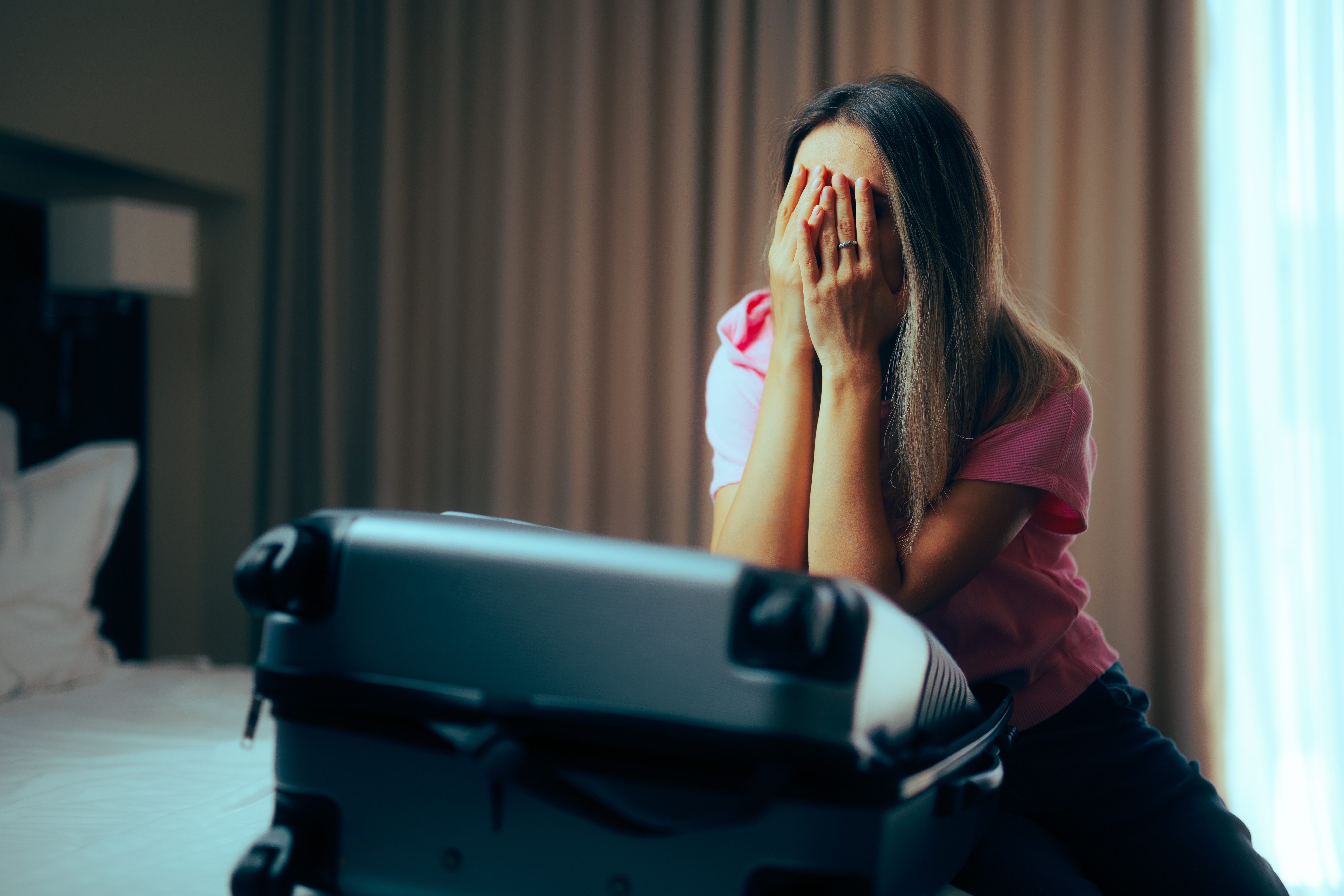 Una chica triste recoge su ropa y se dispone a abandonar su casa | Fuente: Shutterstock.com