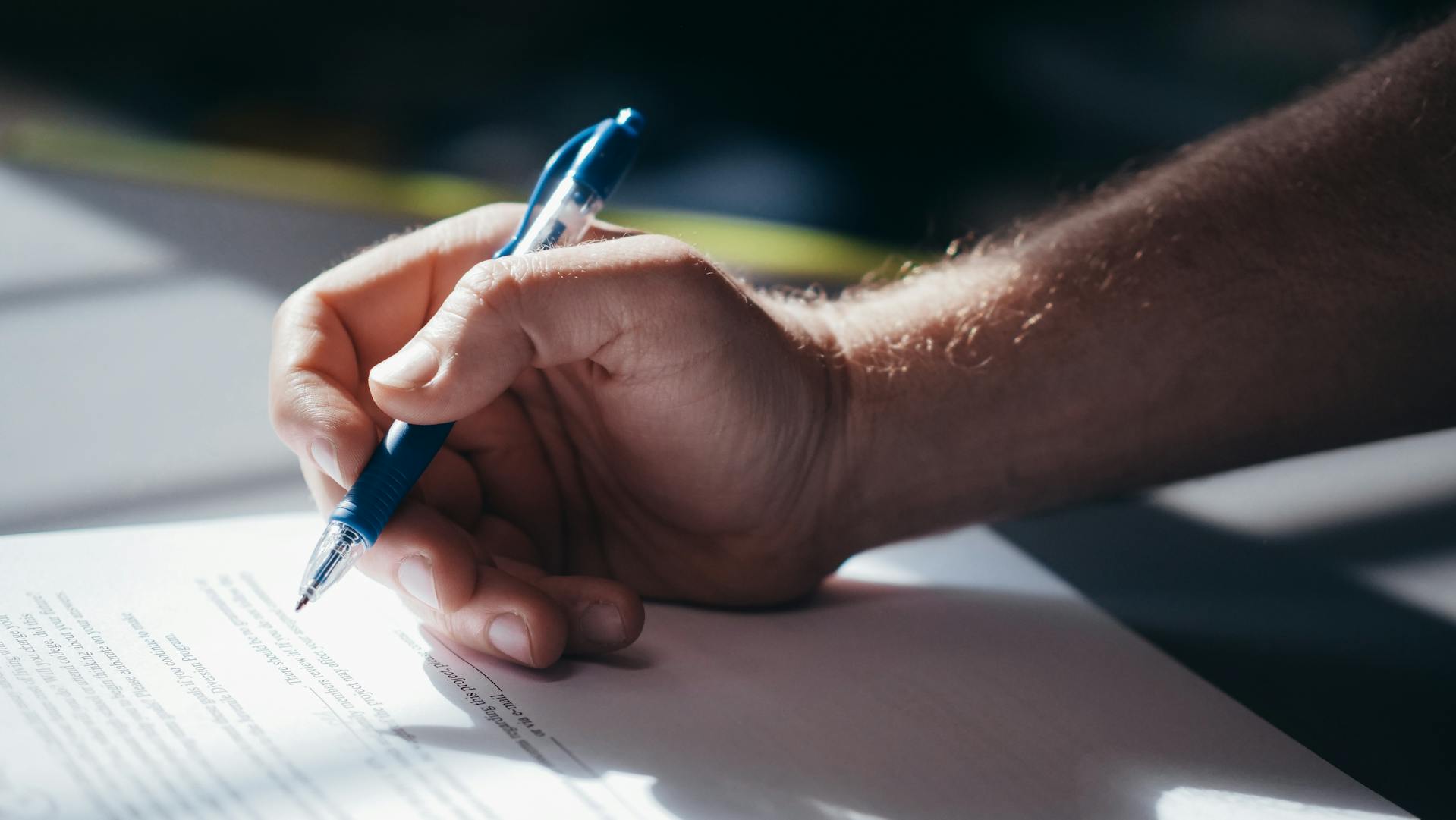 Un homme qui signe des papiers | Source : Pexels