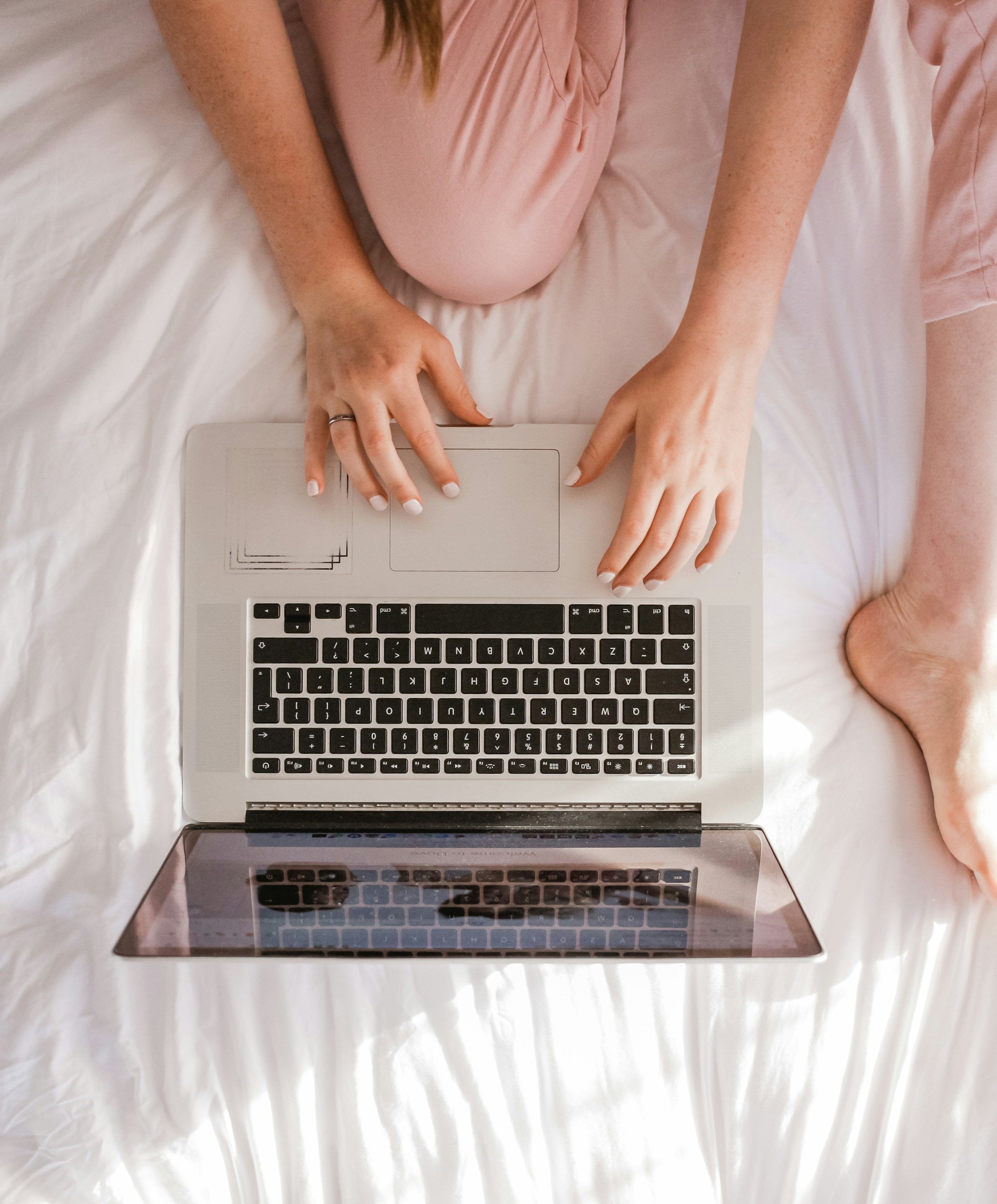 Gros plan d'une femme utilisant son ordinateur portable au lit | Source : Unsplash