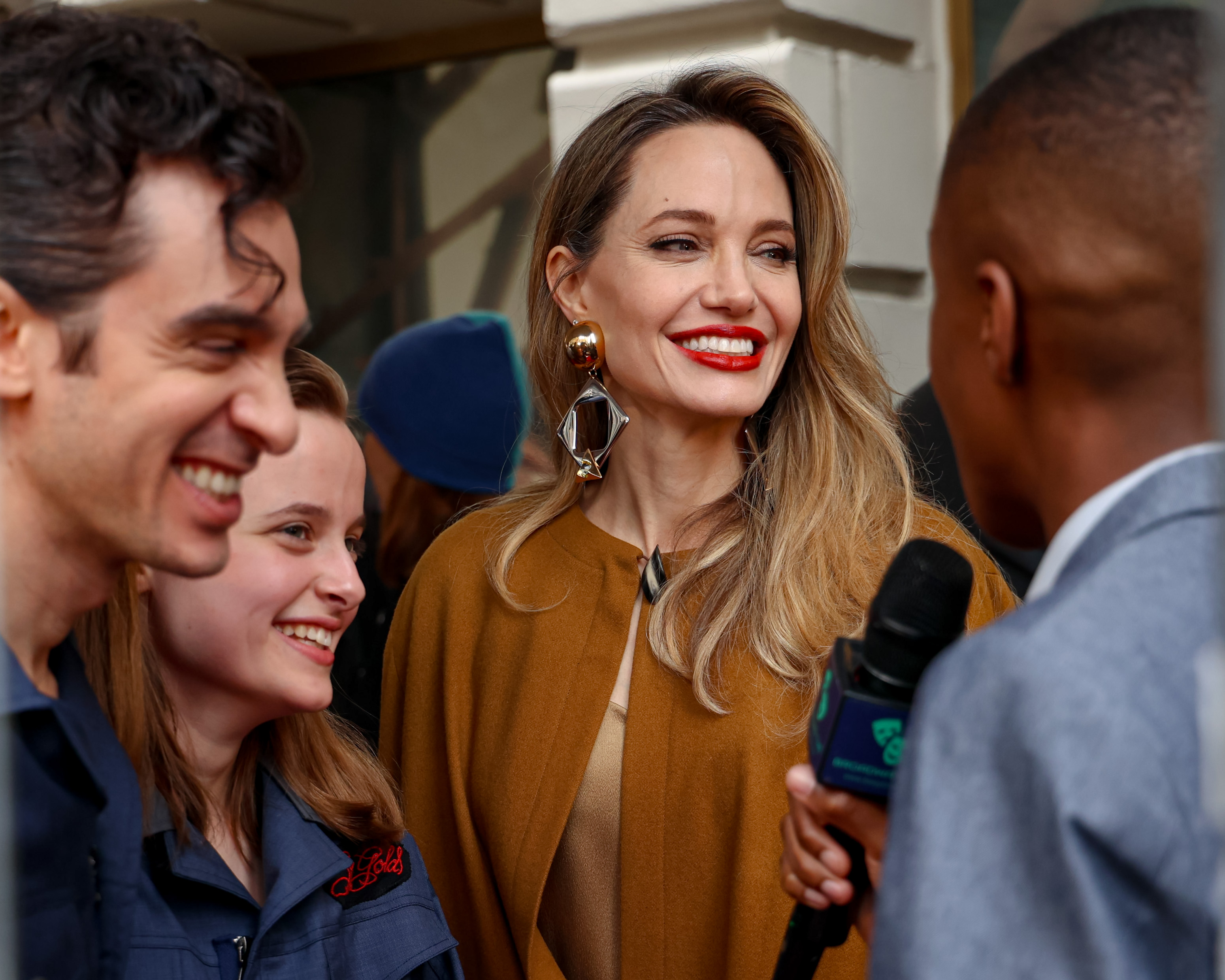 Justin Levine, Vivienne Jolie-Pitt et Angelina Jolie parlent aux médias lors de la soirée d'ouverture de 'The Outsiders' au théâtre Bernard B. Jacobs, le 11 avril 2024, à New York. | Source : Getty Images