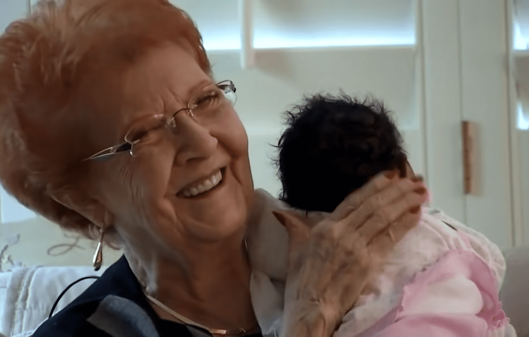 Joy Ringhofer tenant le nouveau-né dans ses bras et riant. │Source : youtube.com/InsideEdition