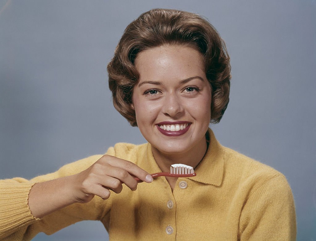 Une femme avec une brosse à dents | source : Getty Images