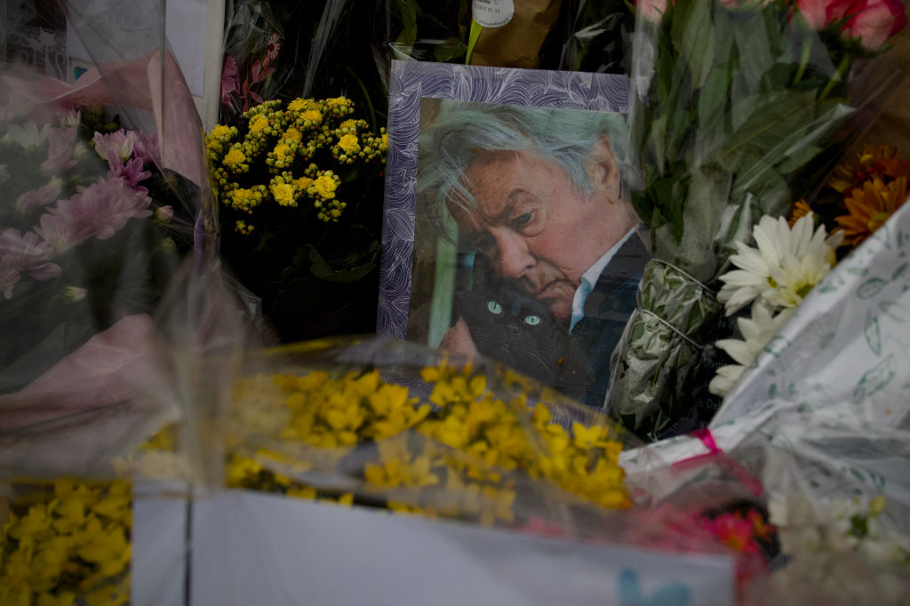 Un portrait d"Alain Delon au milieu de fleurs déposées par ses fans à la porte d'entrée de la propriété de Delon, à Douchy, le 23 août 2024. I Source : Getty Images