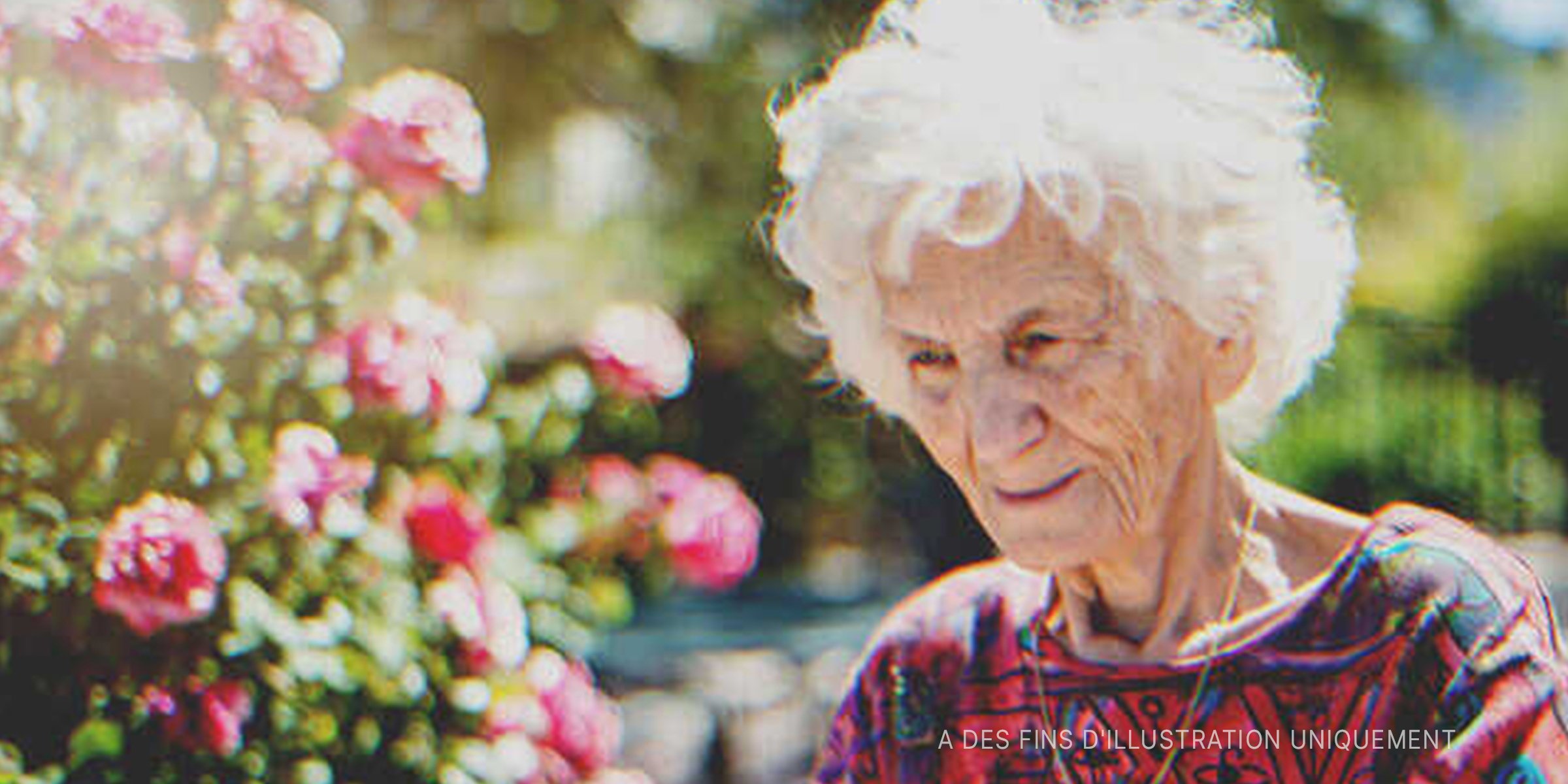Une vieille femme souriant près de fleurs | Source : Getty Images   