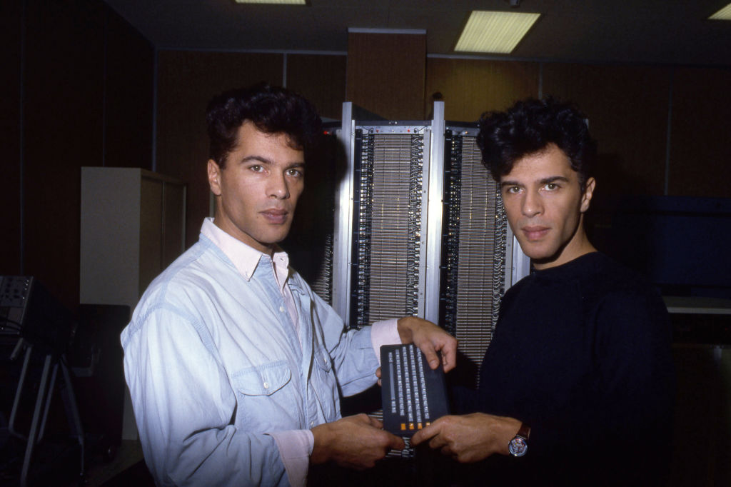 Grichka et Igor Bogdanov présentent un petit ordinateur PBB de 450 grammes à l'Ecole Polytechnique en 1985, Paris, France. Grichka et Igor Bogdanoff présentent PBB un petit ordinateur de 450 grammes devant l'Ecole Polytechnique, en 1985, Paris, France. | Source : Getty Images