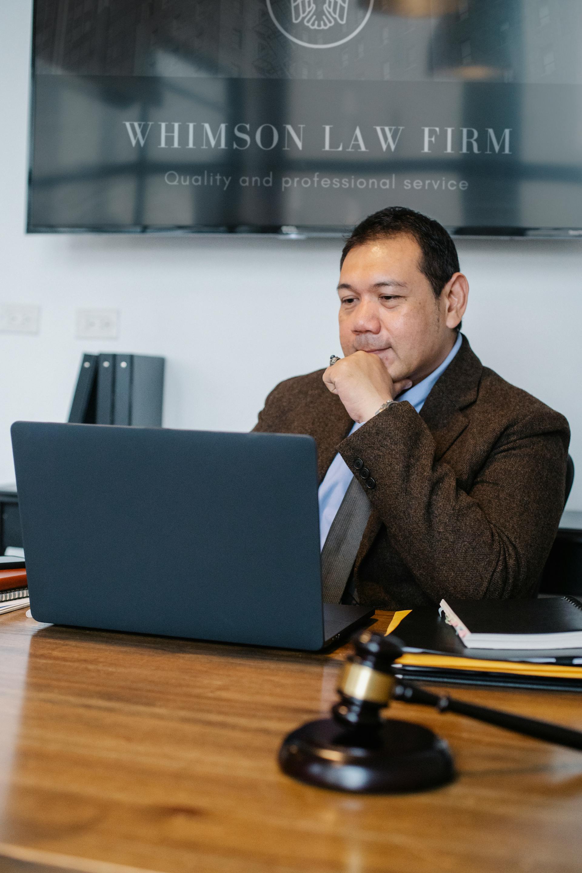 Un avocat de sexe masculin utilisant un ordinateur portable dans son bureau | Source : Pexels
