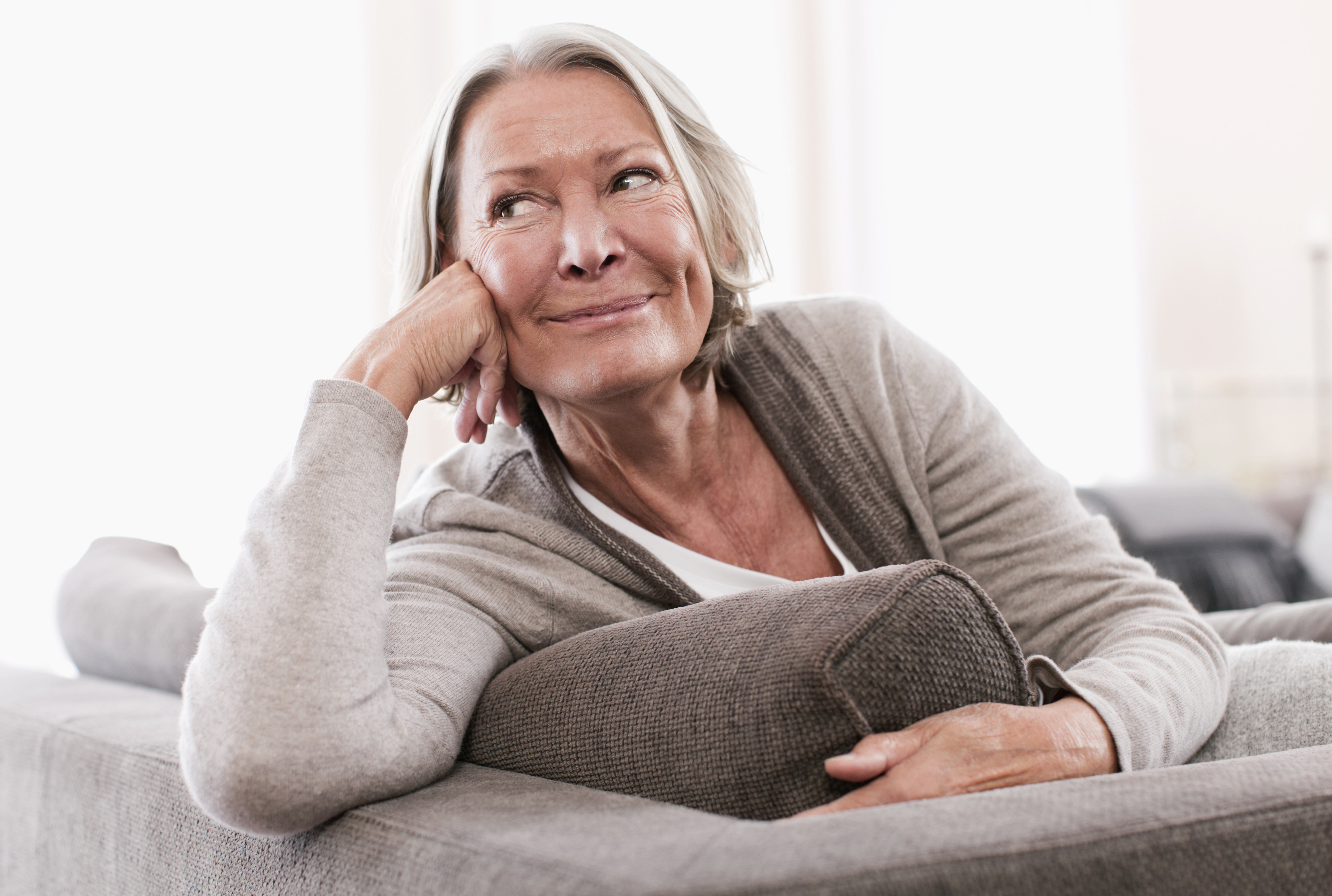 Une femme âgée regardant au loin, souriante | Source : Getty Images