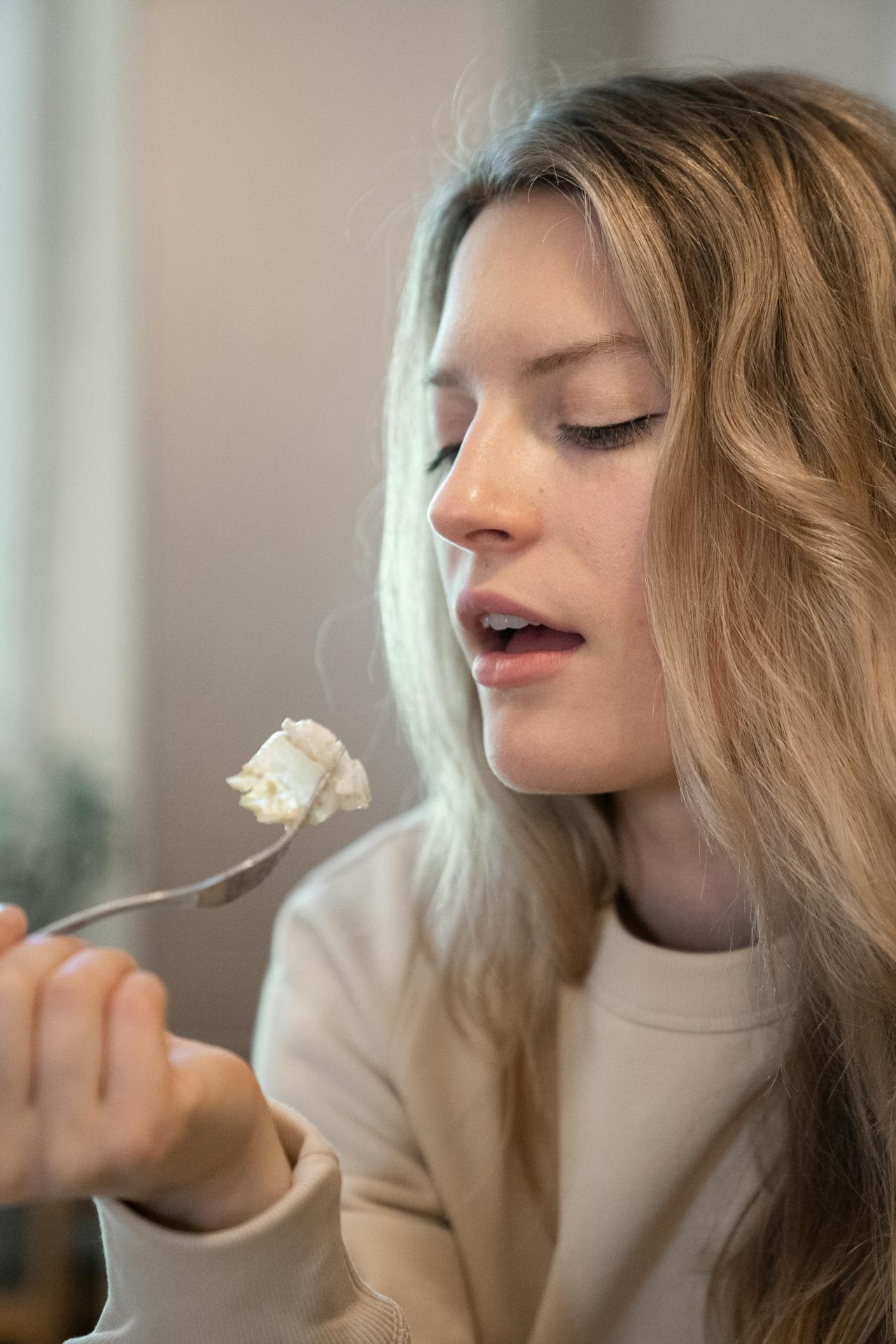 Une femme mangeant de la nourriture à l'aide d'une fourchette | Source : Pexels