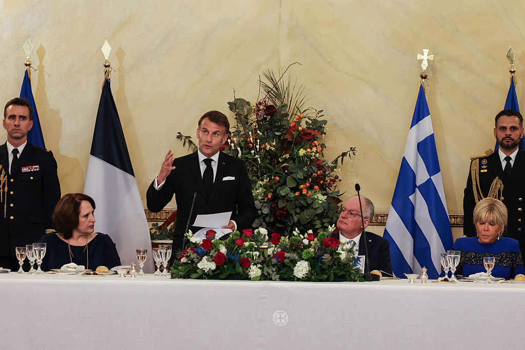 Le président français Emmanuel Macron (2e à gauche) prononce un discours aux côtés de Fani Stathopoulou (à gauche), épouse du président grec, de Konstantinos Tasoulas (2e à droite), président grec, et de Brigitte Macron (à droite), épouse du président français, lors d'un dîner officiel au palais présidentiel d'Athènes, le 24 avril 2026 I Source : Getty Images