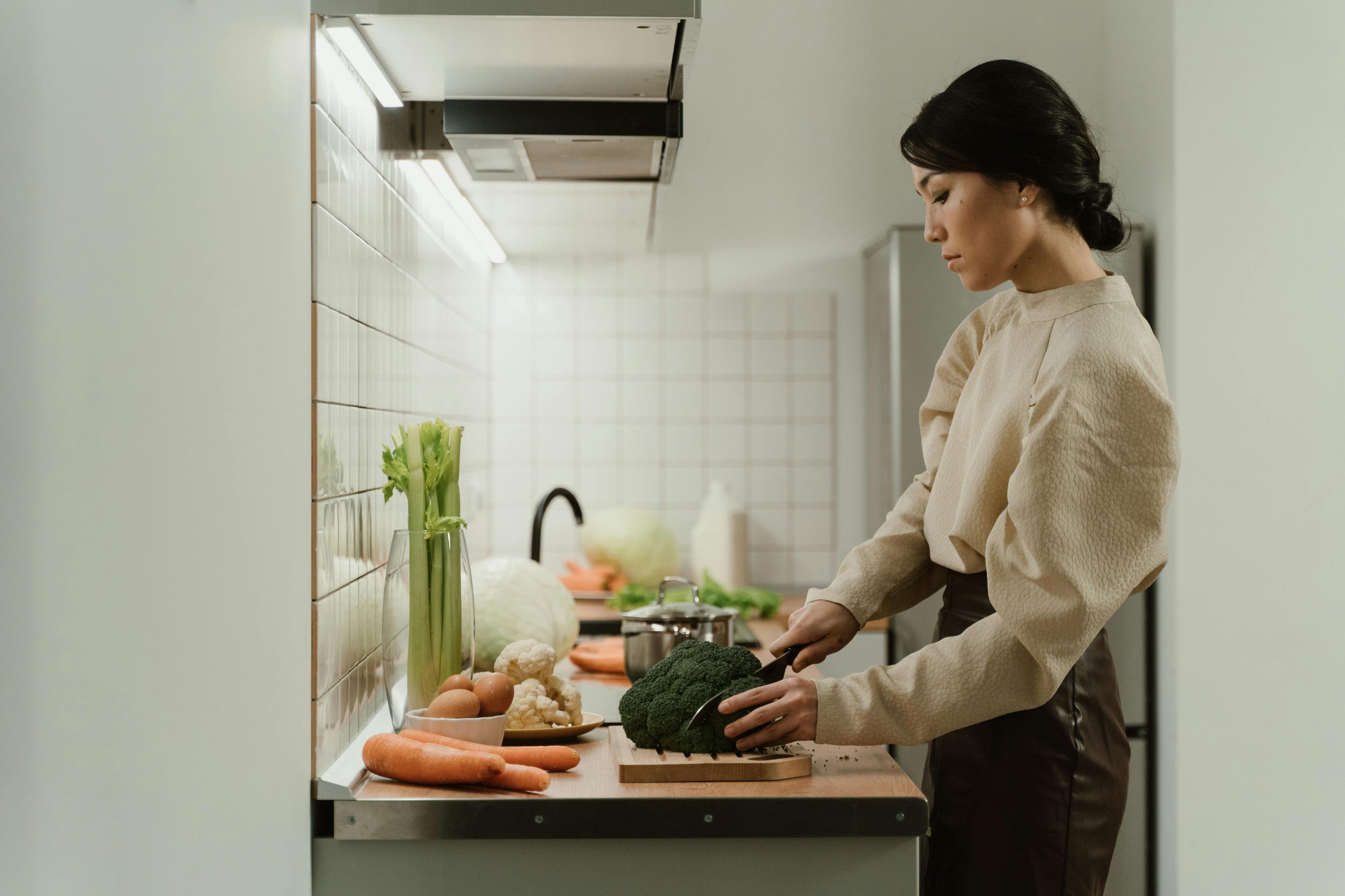 Une femme en train de couper des légumes. À des fins d'illustration uniquement | Source : Pexels