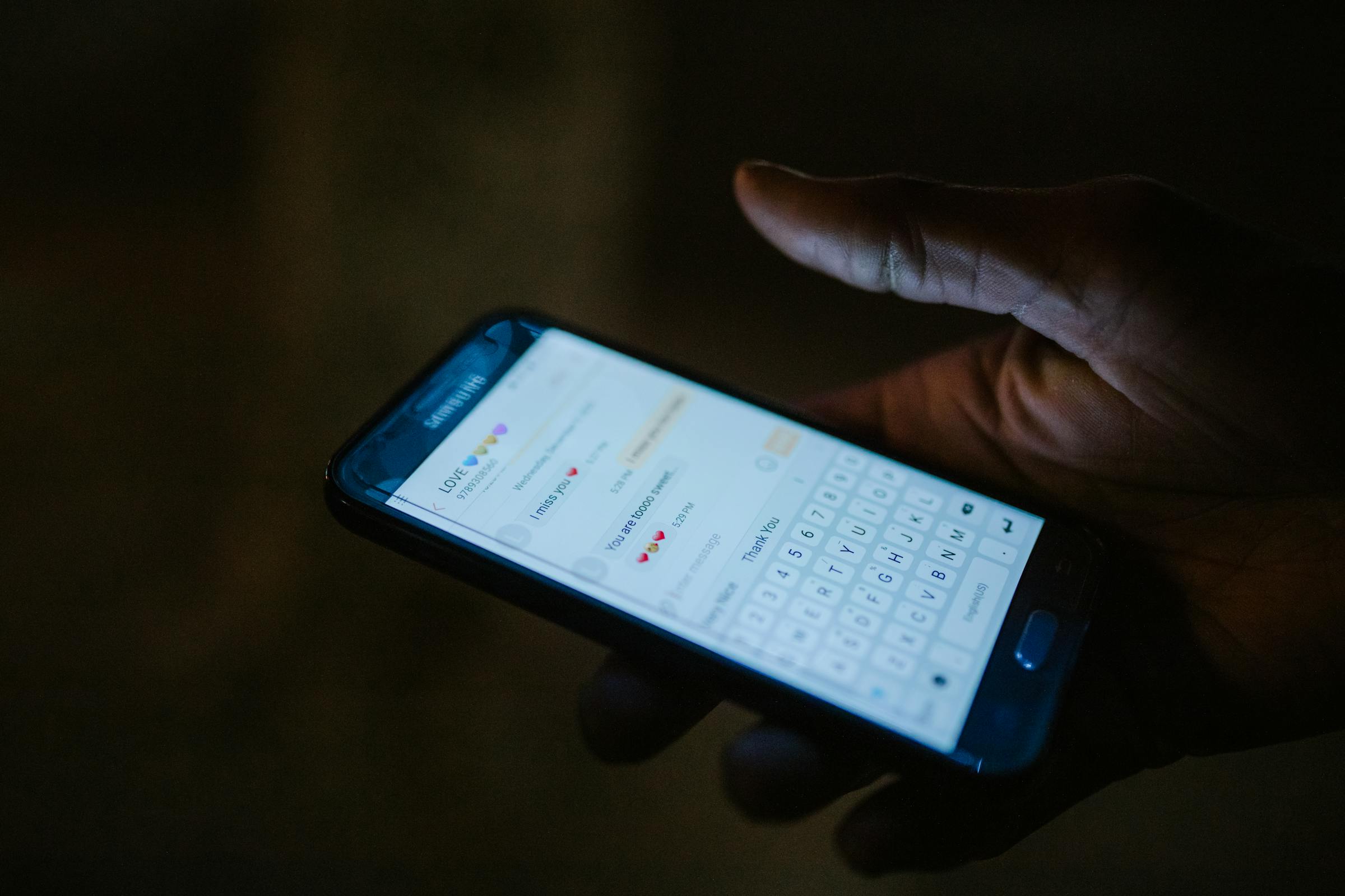 Un téléphone montrant une conversation textuelle avec des emojis | Source : Pexels