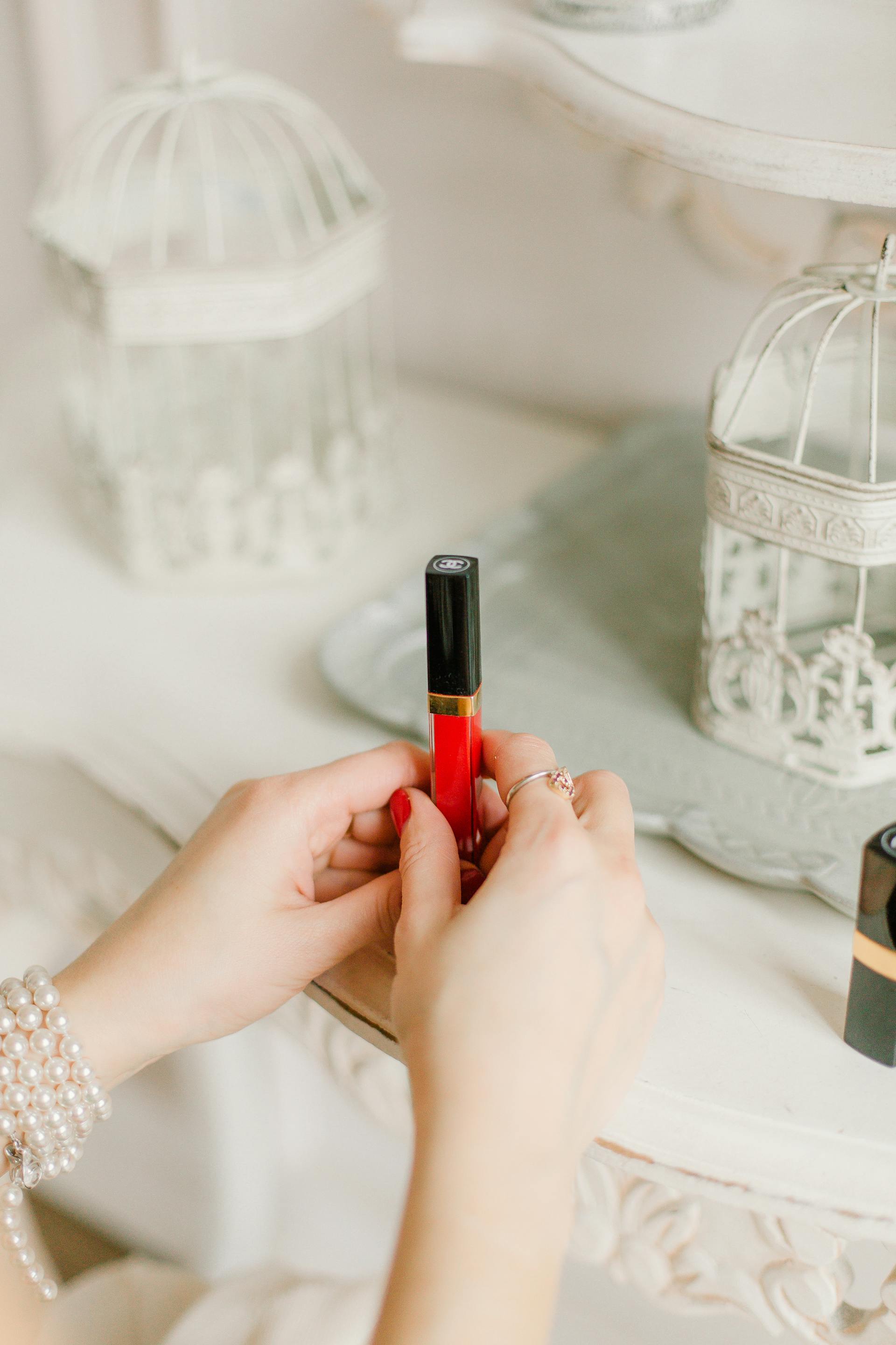 Gros plan d'une femme tenant un lipgloss rouge | Source : Pexels