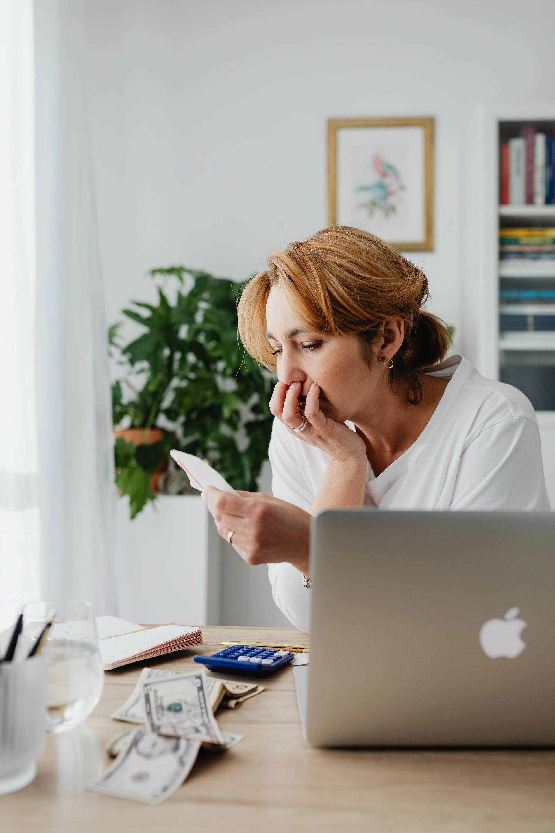 Une femme pensive assise à un bureau | Source : Pexels