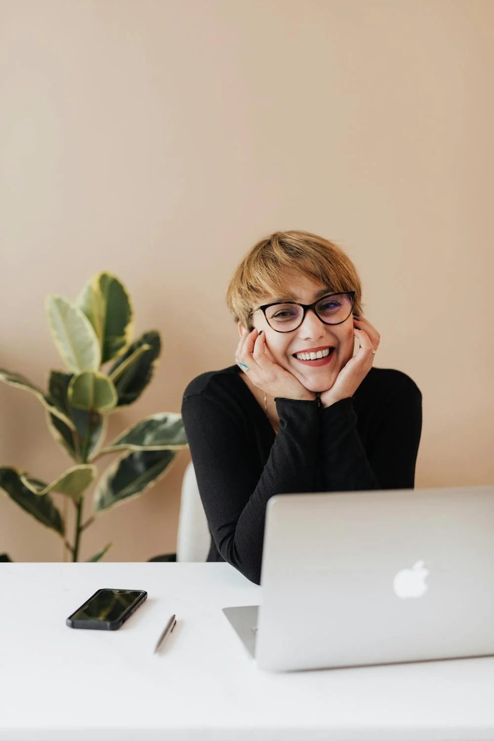 Une femme souriante dans son bureau | Source : Pexels