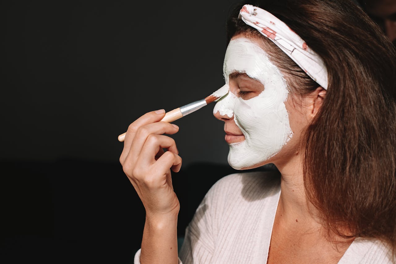 Une femme appliquant un masque sur son visage | Source : Pexels