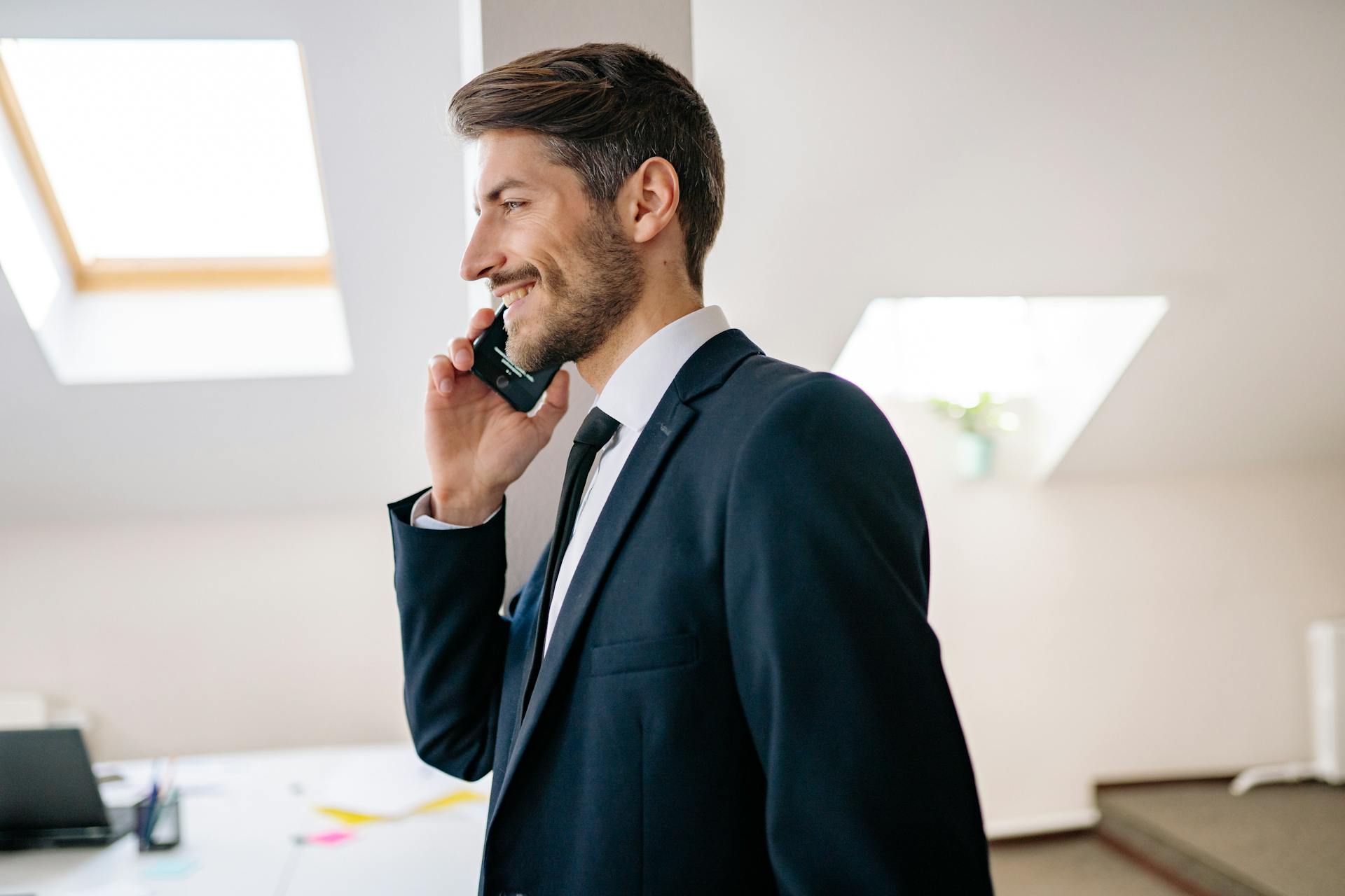 Un homme souriant pendant un appel téléphonique | Source : Pexels