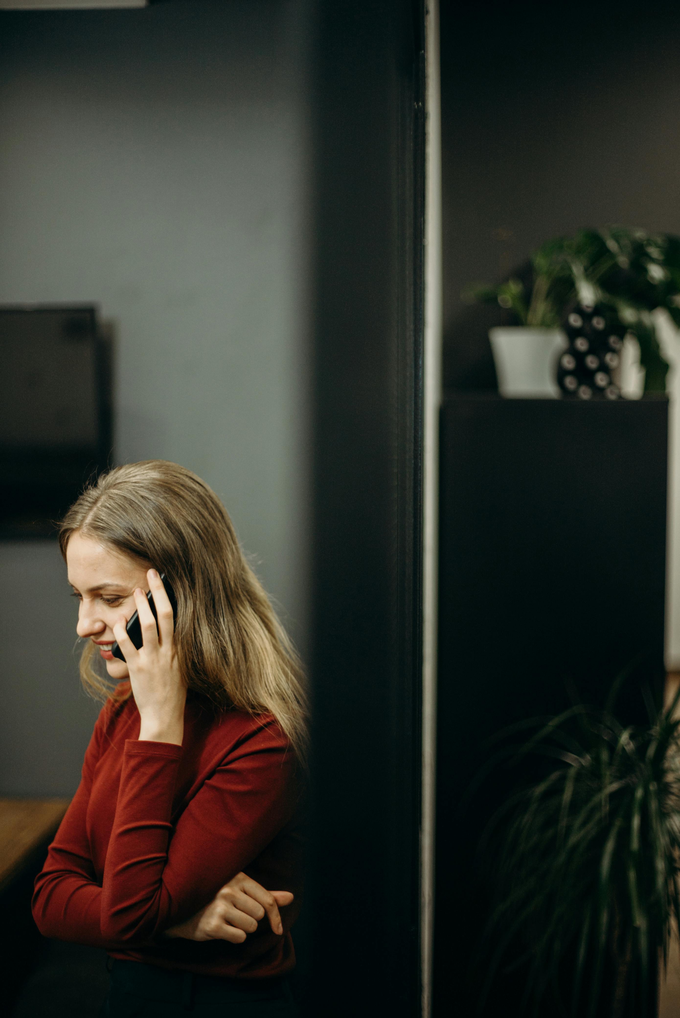 Une femme souriante sur son téléphone | Source : Pexels