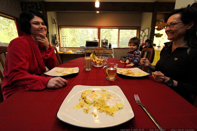 Une photo de deux femmes se souriant l'une à l'autre alors qu'elles sont assises de l'autre côté de la table avec un jeune enfant | Source : Flickr