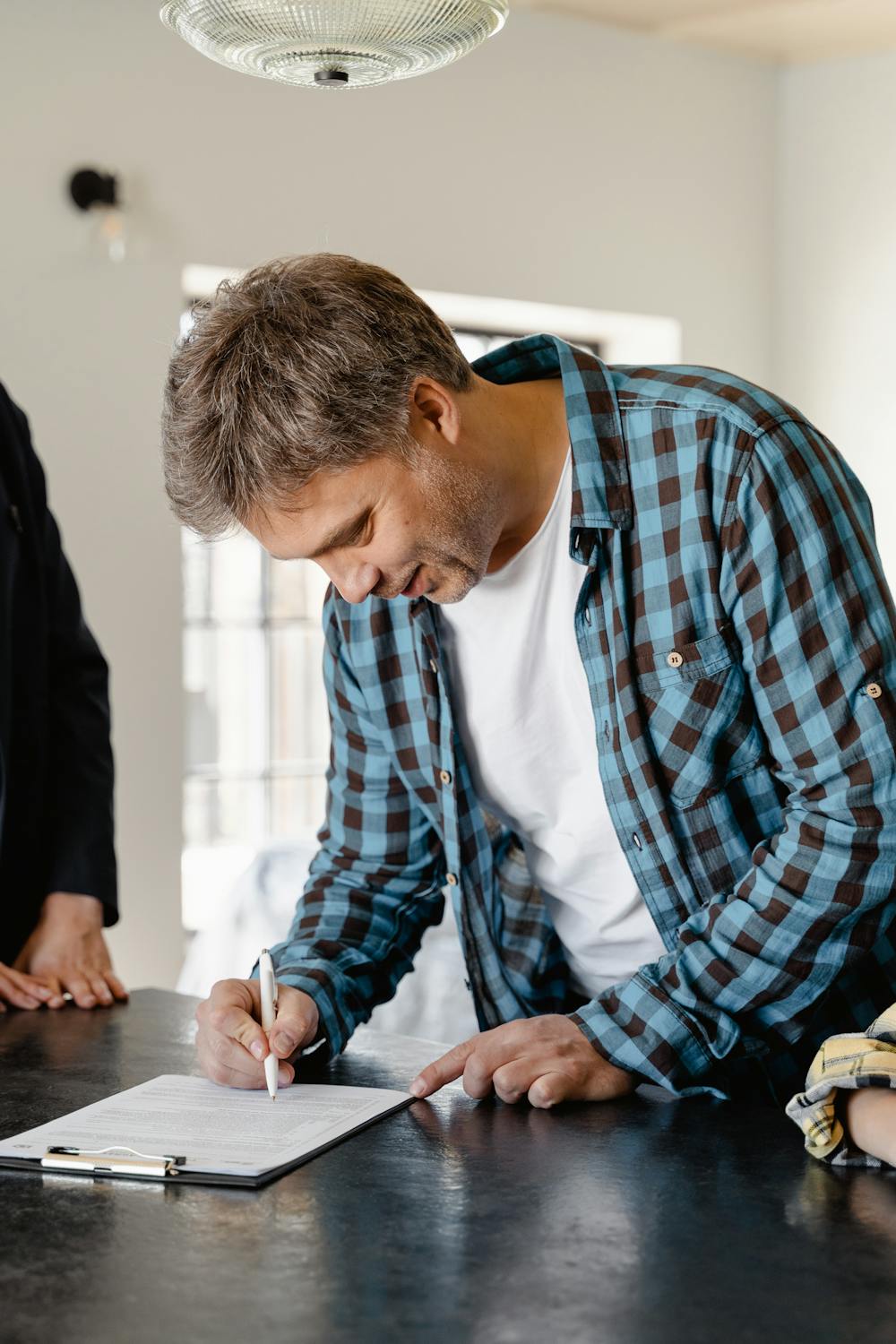 A man signing papers | Source: Pexels