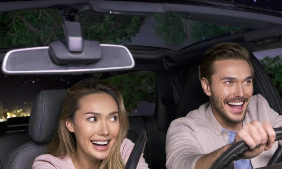 Un homme et une femme à l'air heureux conduisant dans une voiture | Source : Midjourney