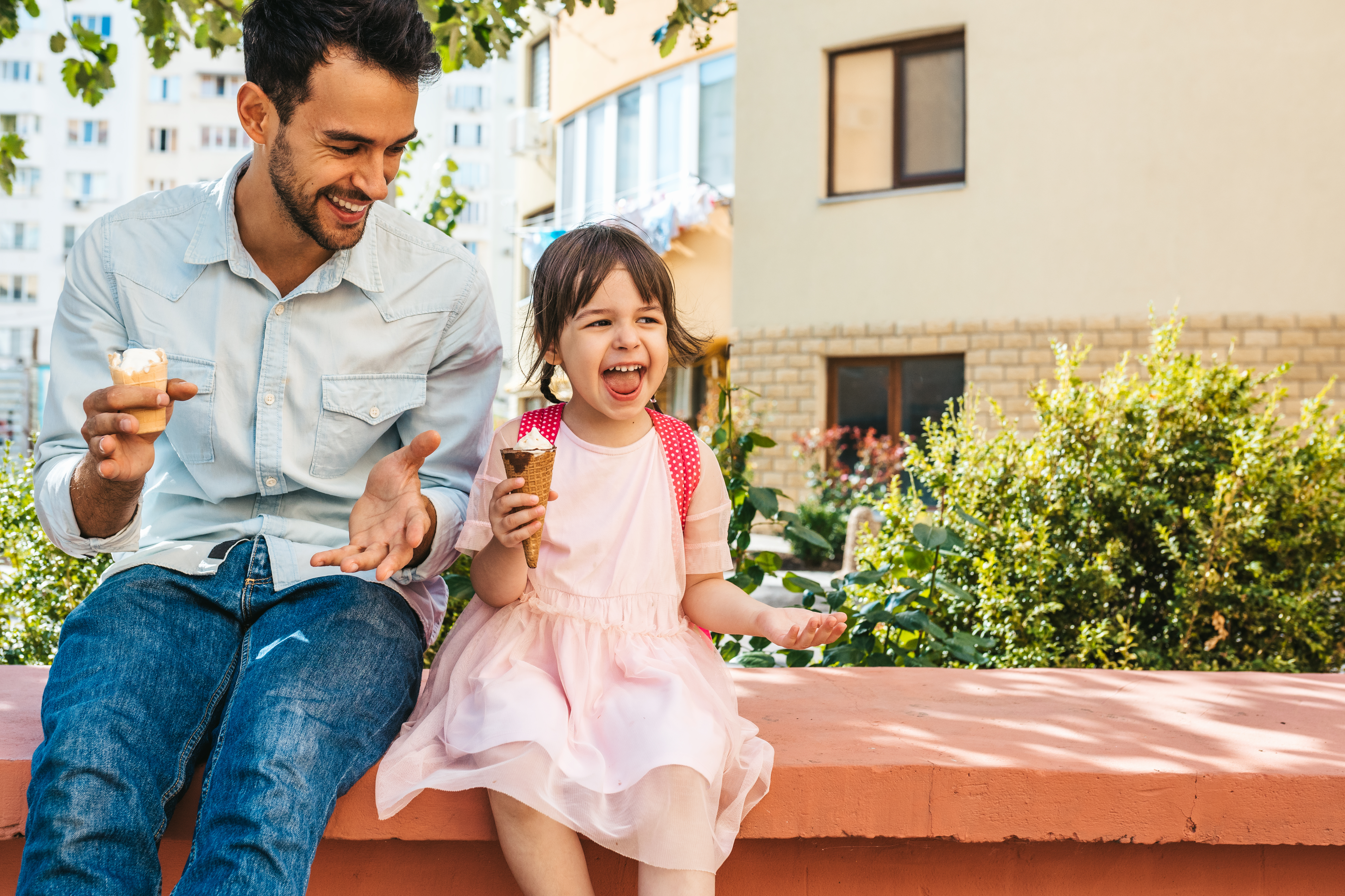 Un homme et sa fille dégustant une glace en plein air. | Source : Shutterstock