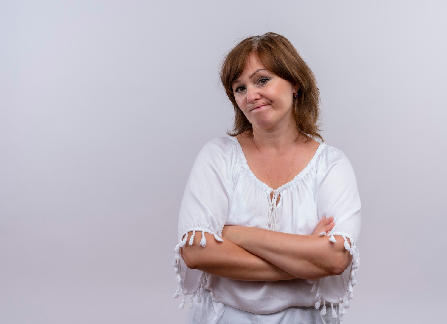Une femme pensive avec les bras croisés | Source : Freepik