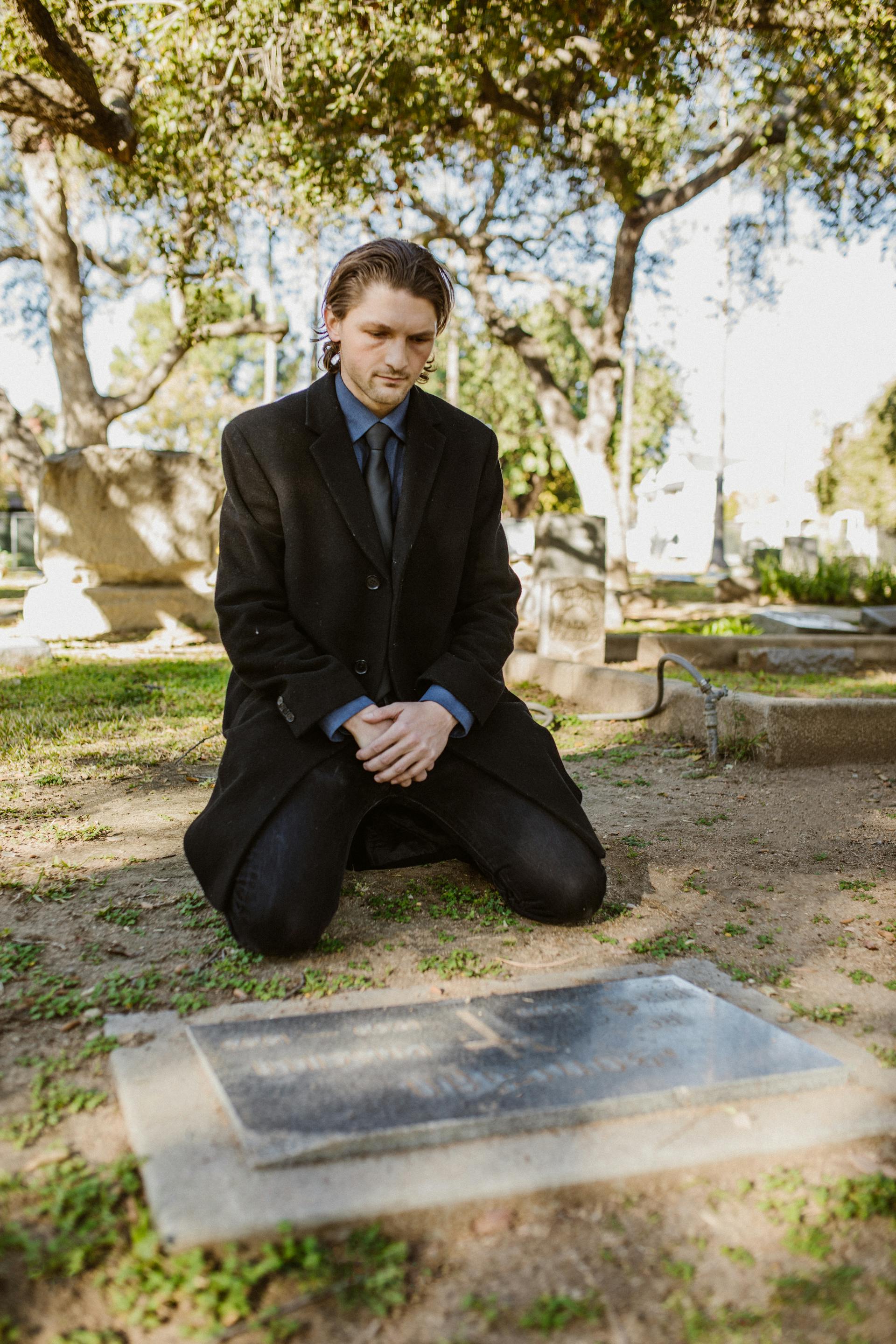 Un jeune homme devant une tombe | Source : Pexels