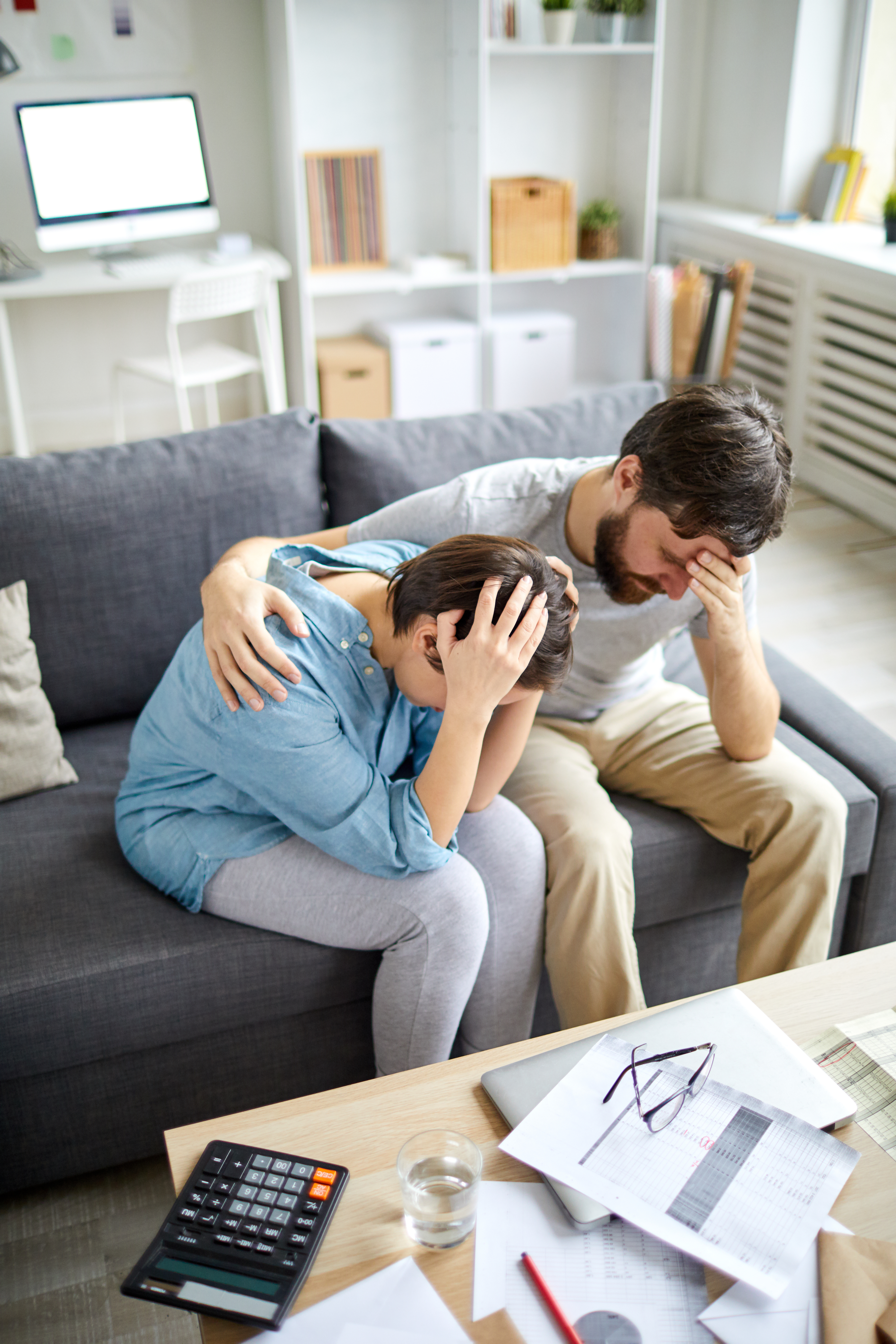 Un homme désemparé entoure de son bras une femme désemparée | Source : Shutterstock