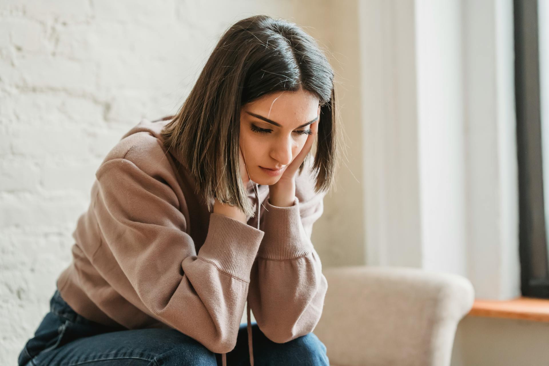 Une femme anxieuse assise sur le canapé | Source : Pexels