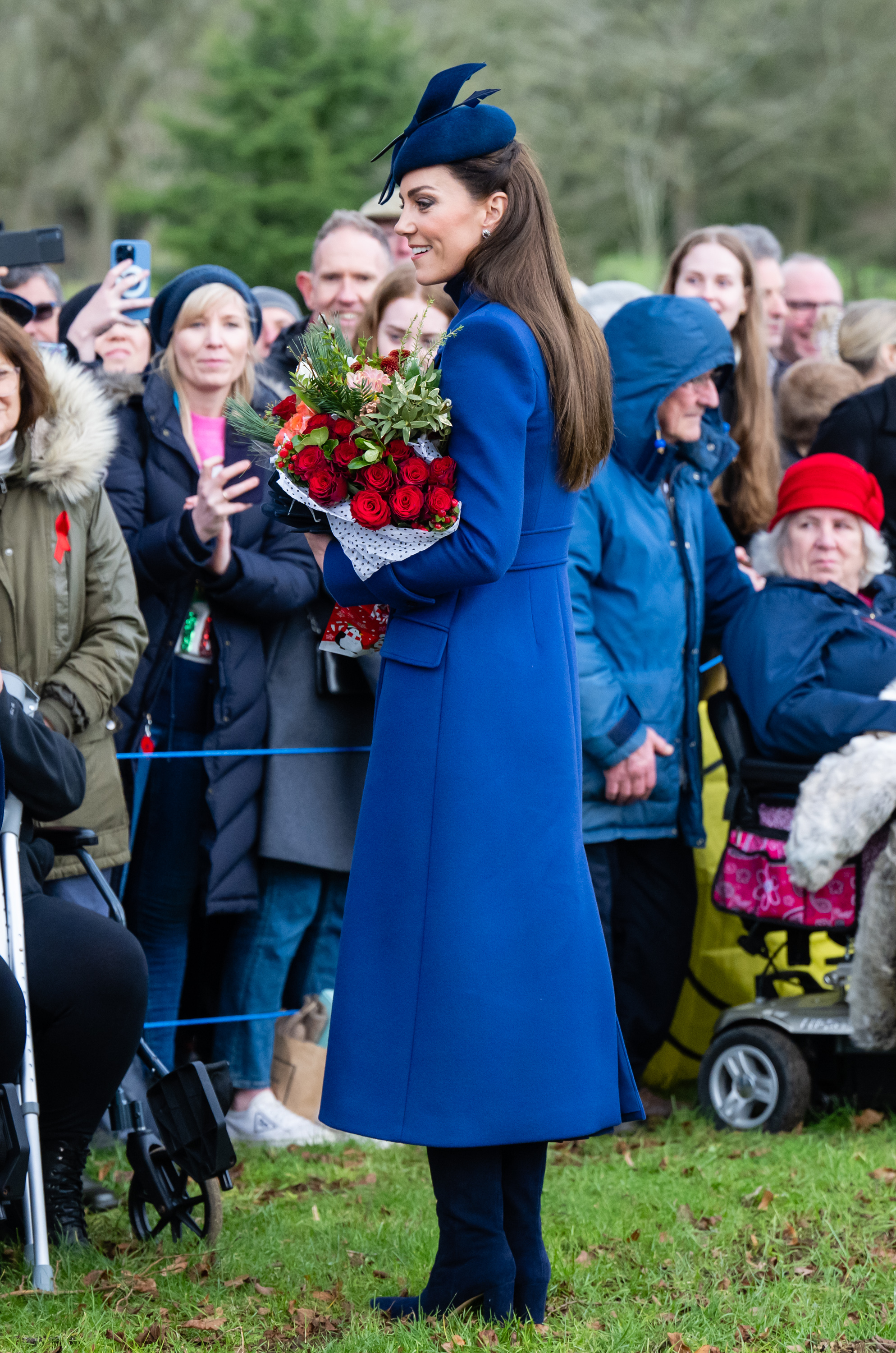 Catherine, princesse de Galles saluant la foule alors qu'elle porte un bouquet de roses sur le chemin de l'office du matin de Noël à l'église St. Mary Magdalene le 25 décembre 2023 à Sandringham, Norfolk | Source : Getty Images