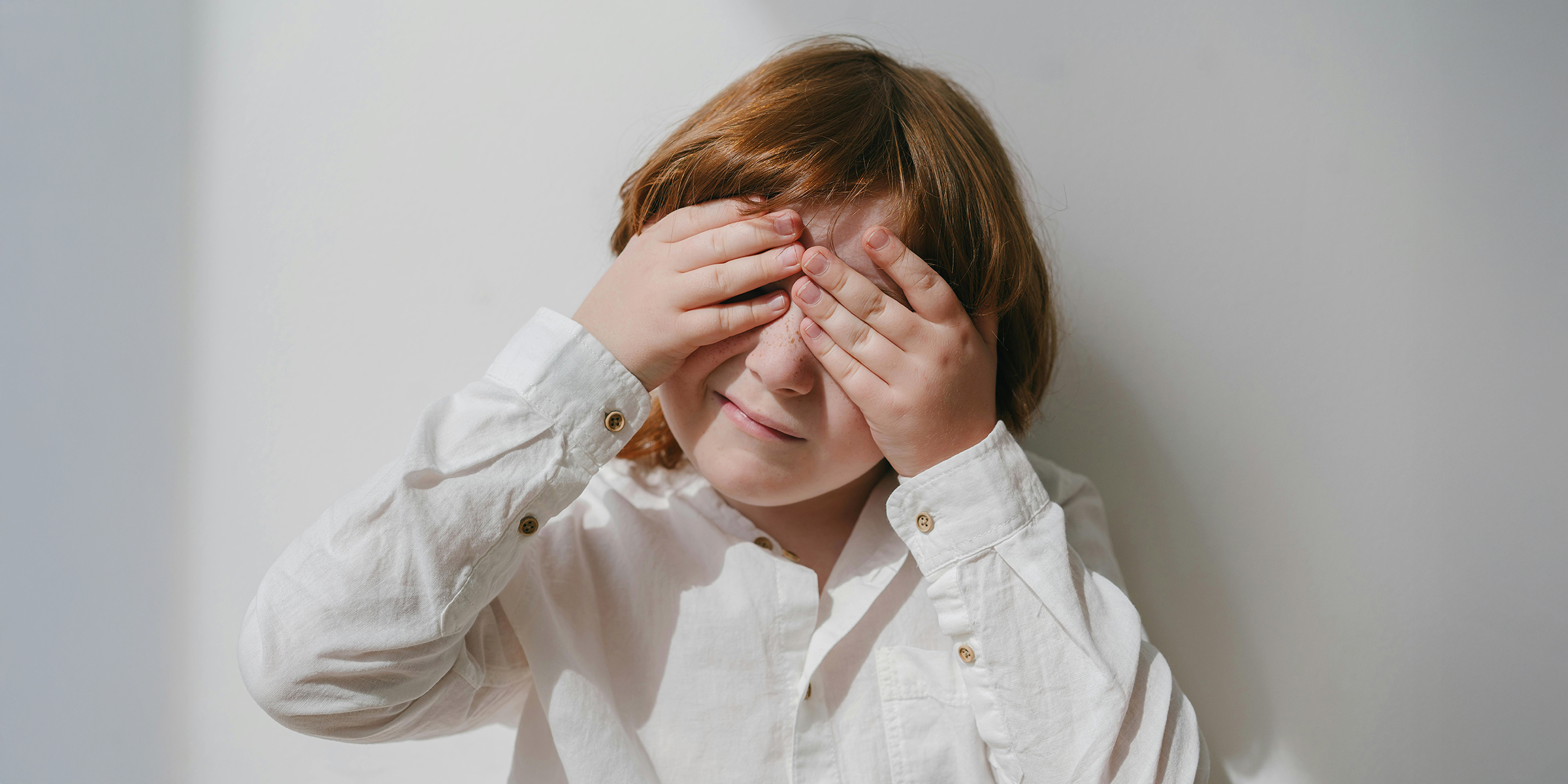 Garçon cachant son visage avec ses mains | Source : Pexels