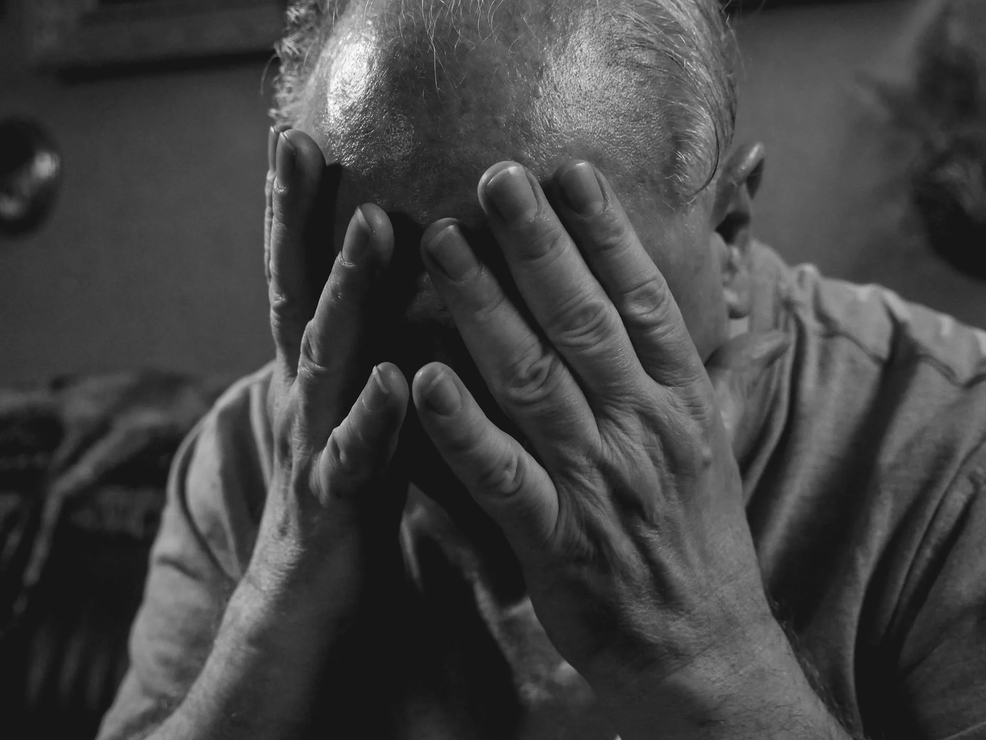 An elderly man covering his face | Source: Pexels