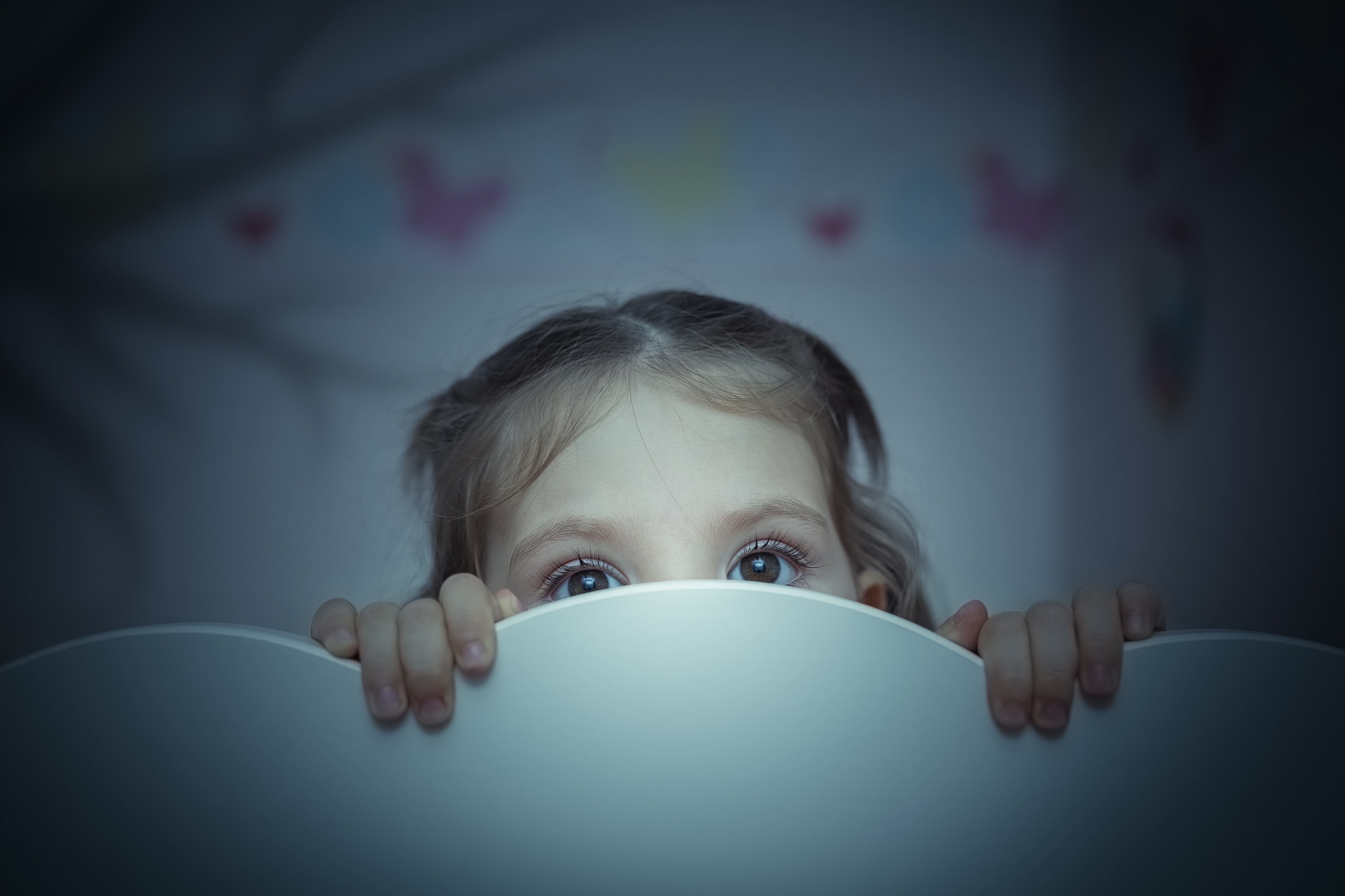 Une petite fille qui se cache derrière une surface blanche | Source : Shutterstock